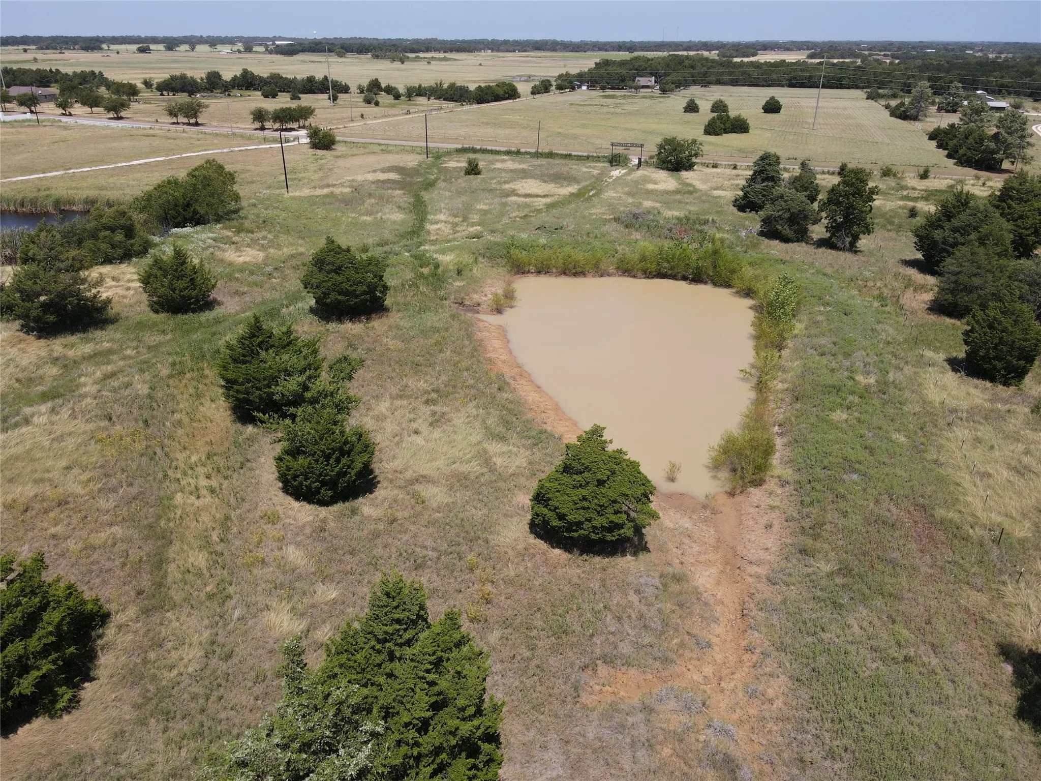 Pond feature with surrounding natural landscape and distant treeline