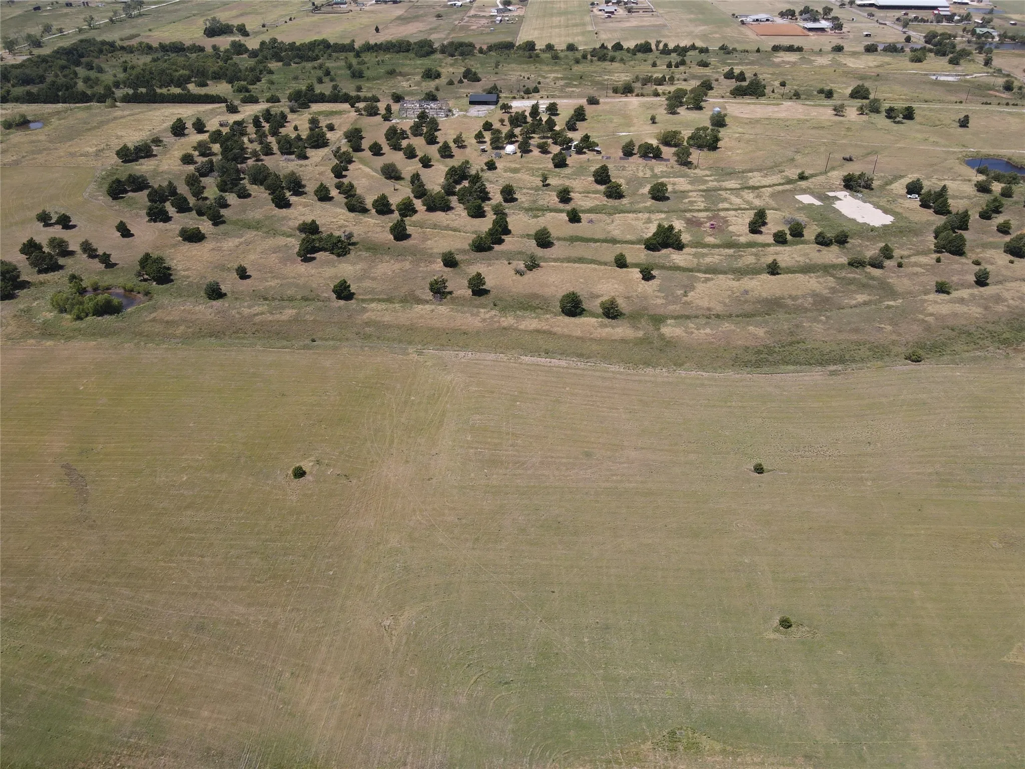 Expansive undeveloped land with scattered trees and natural terrain