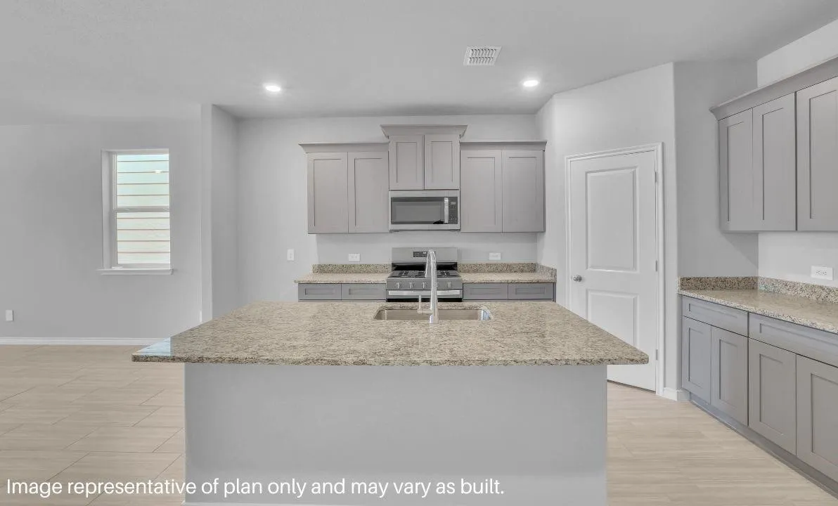 Kitchen featuring a central island, stainless steel appliances, light-toned cabinetry, and wood-finish flooring