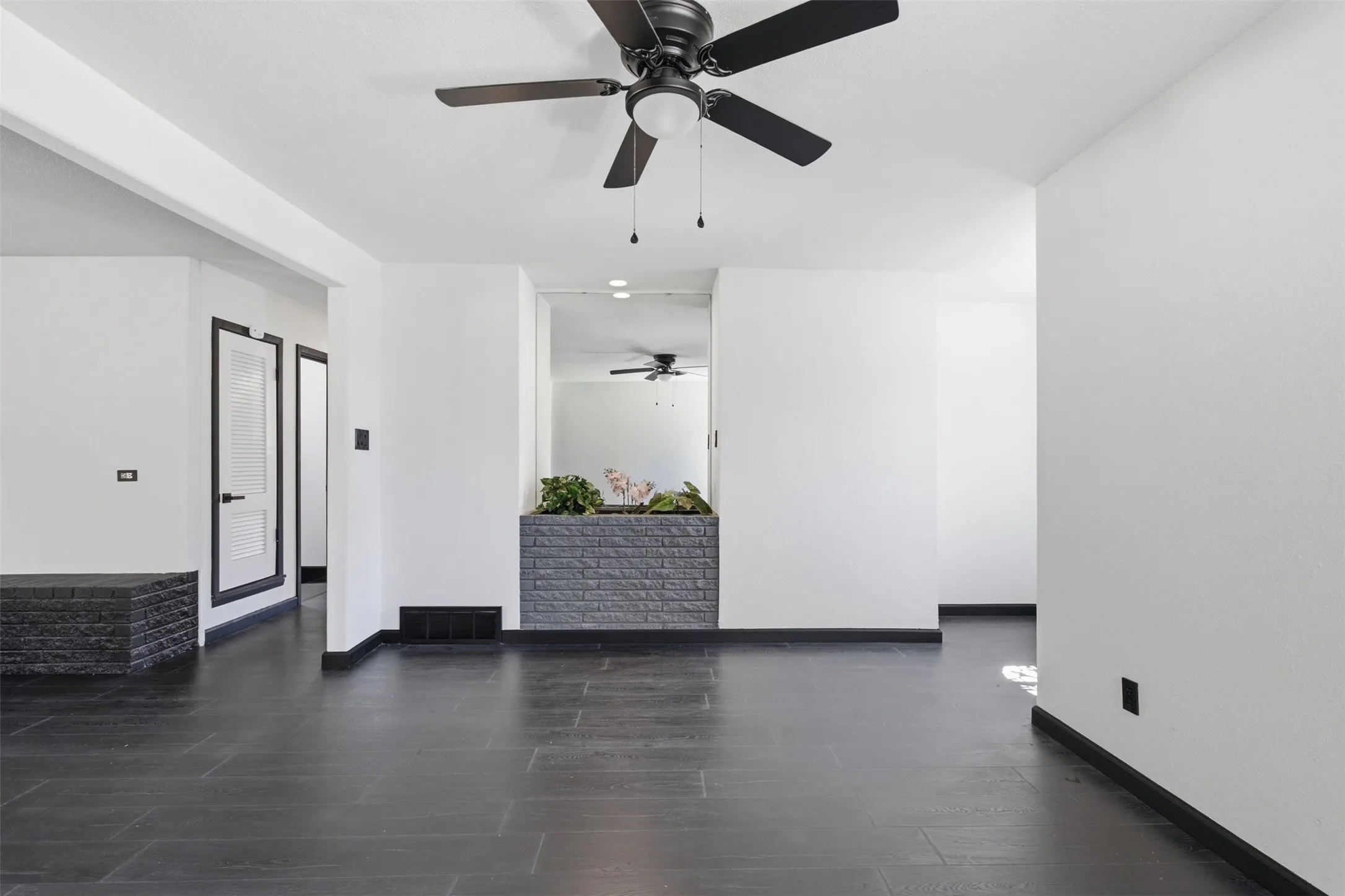 Dark wood-finish flooring with white walls