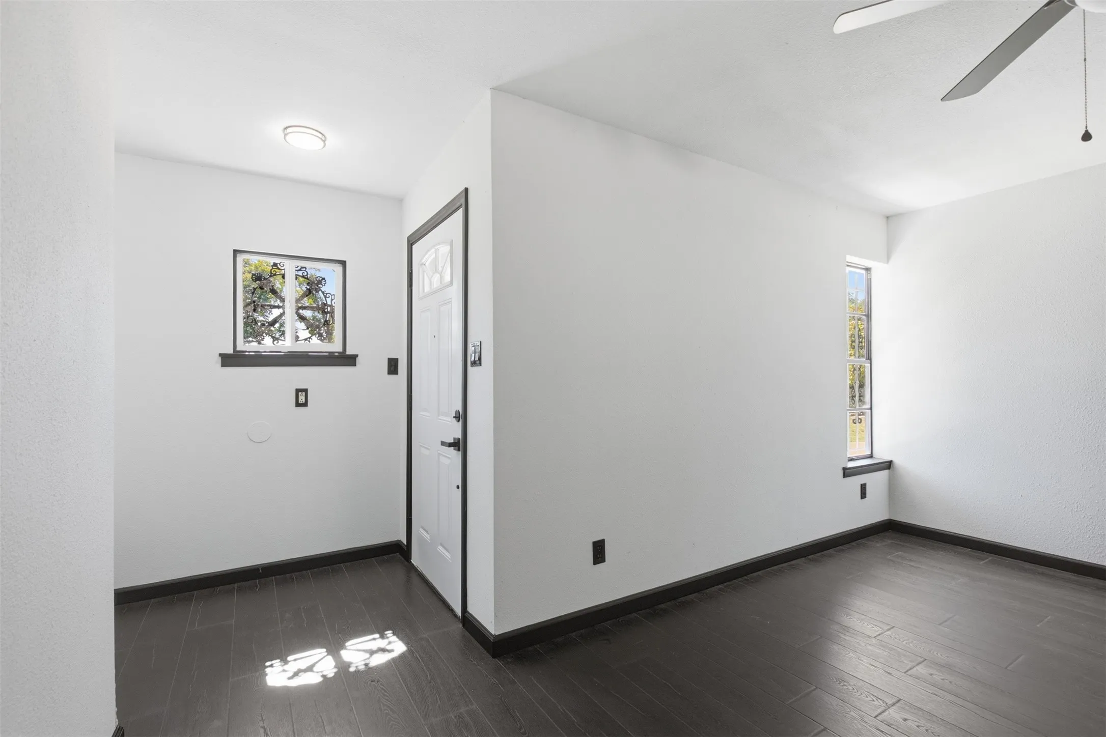 Dark wood-finish flooring with white walls and trim
