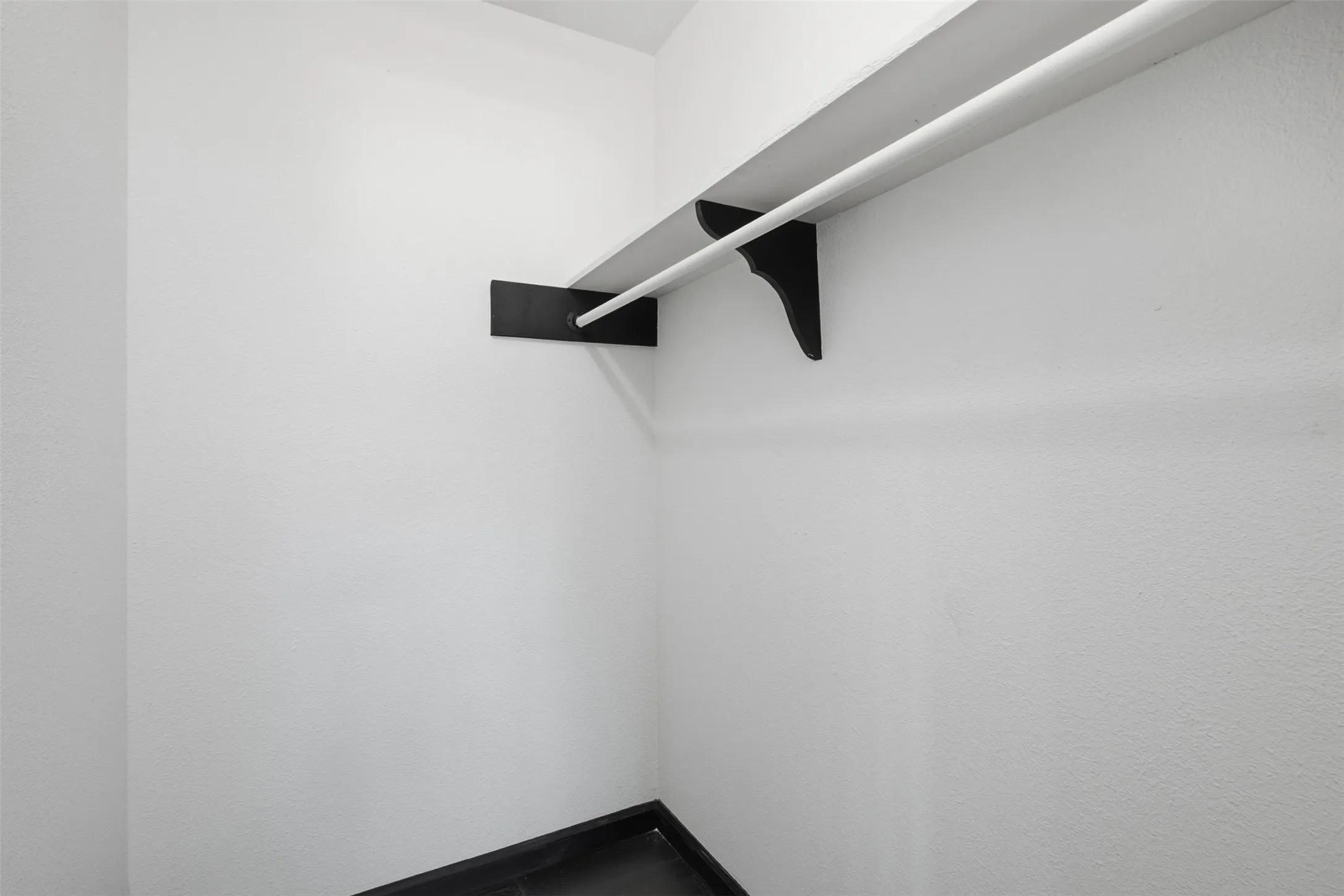 White-painted walls with integrated shelving and hanging rod