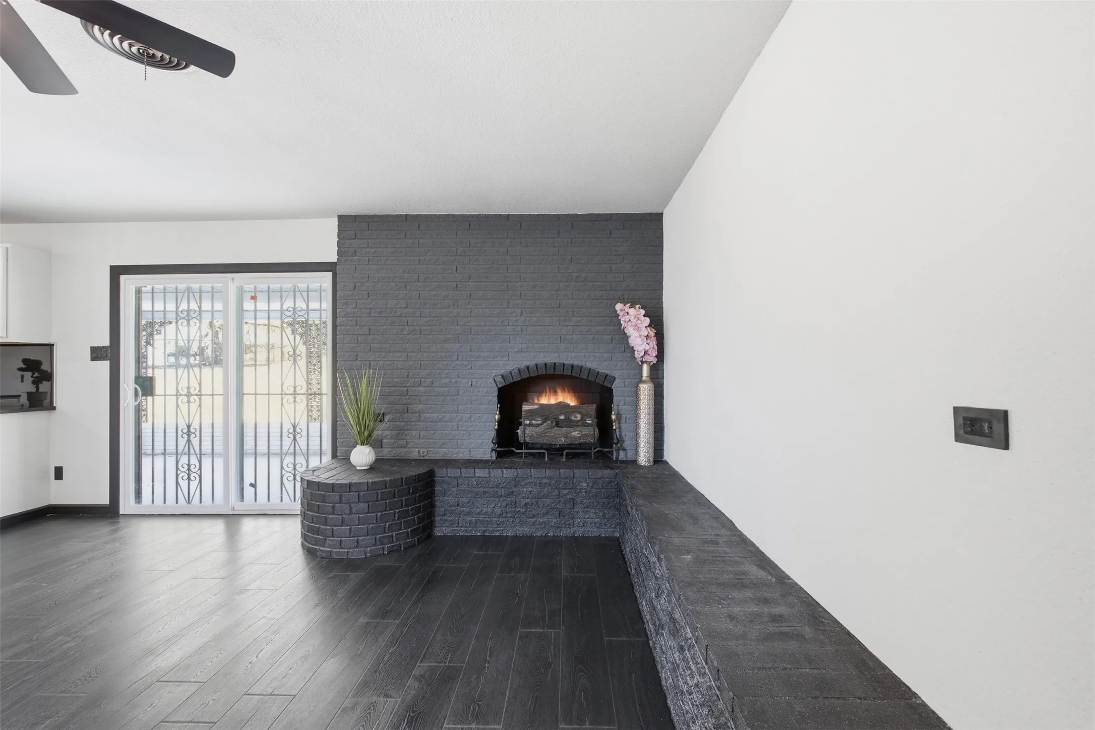 Dark wood-finish flooring with a modern ceiling fan