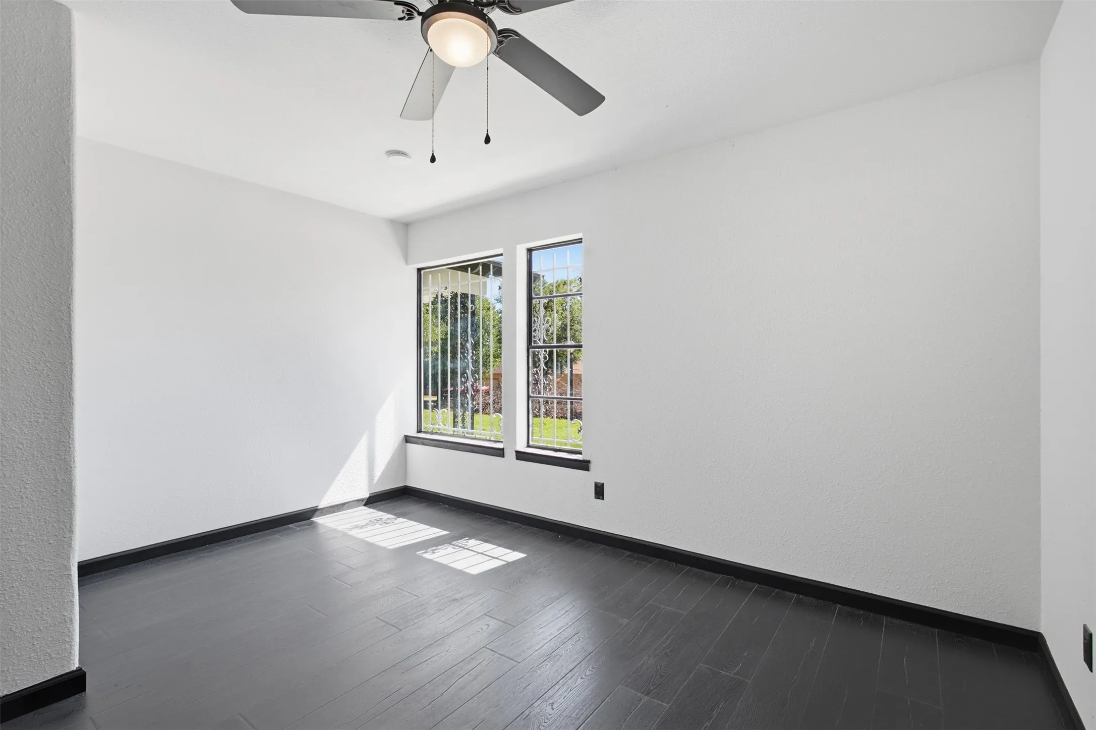 Dark wood-finish flooring with crisp white walls