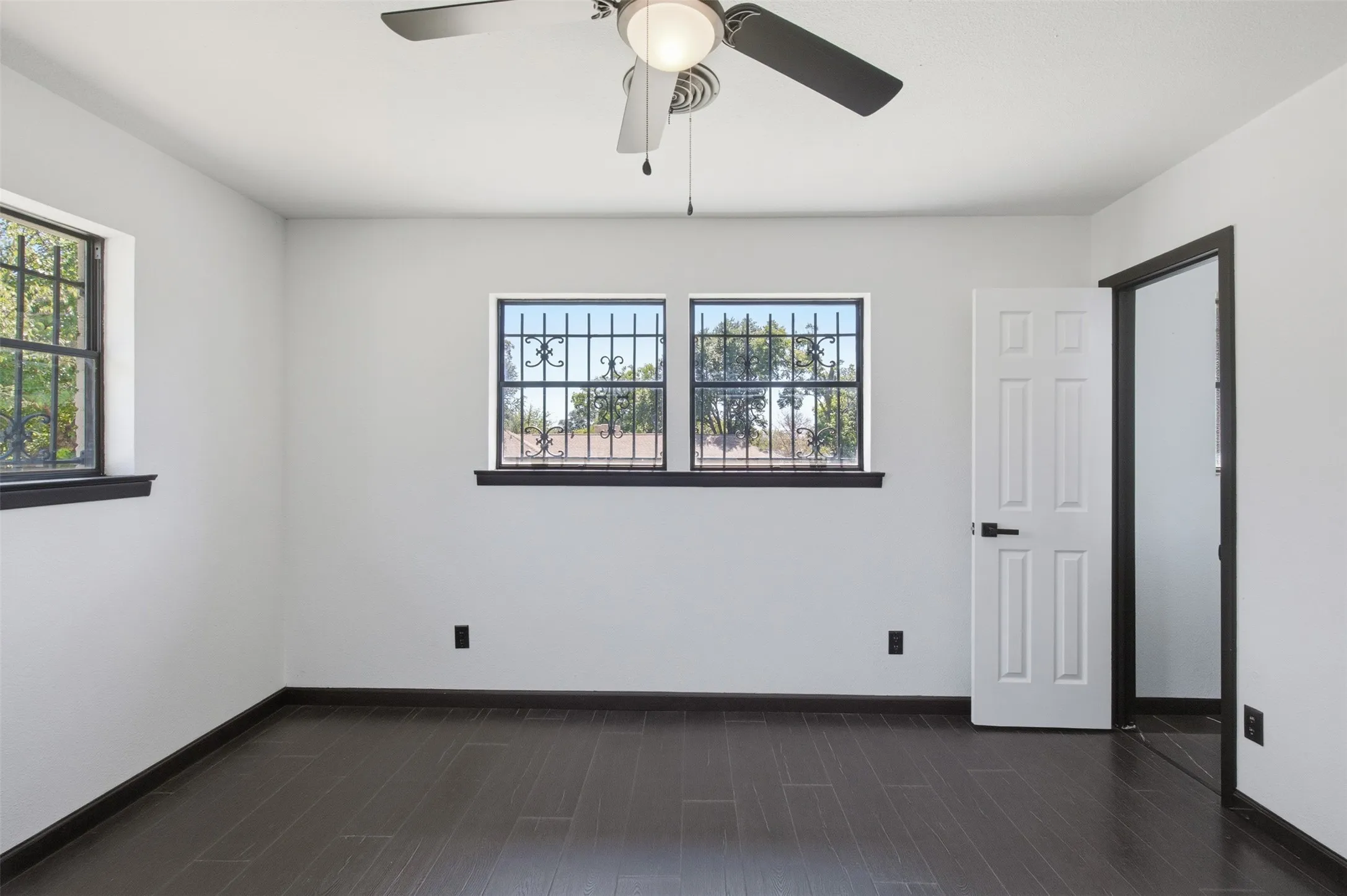 Wood-finish flooring with dark trim, recessed lighting, and a ceiling fan