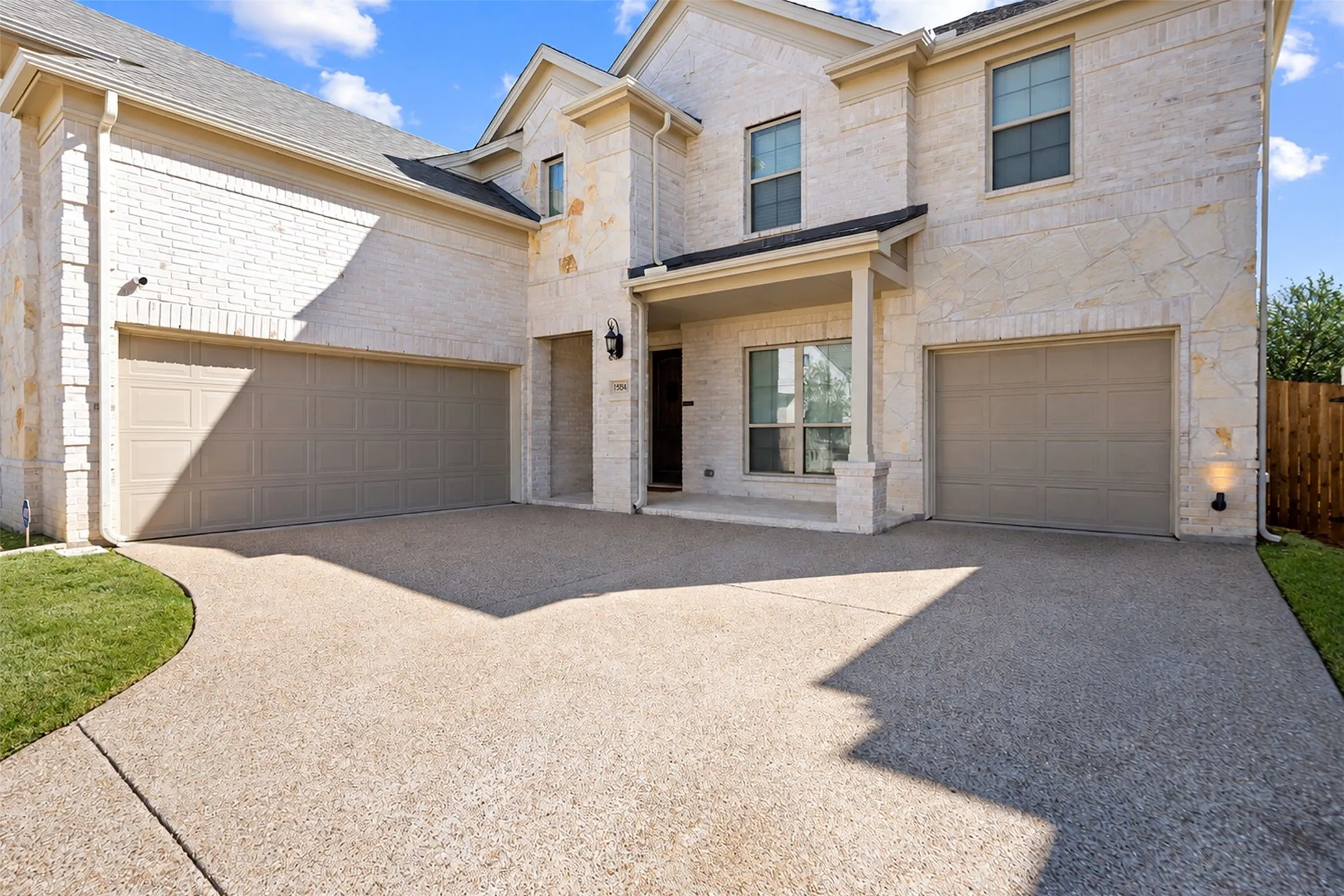 Stone facade with brick accents and two garage doors