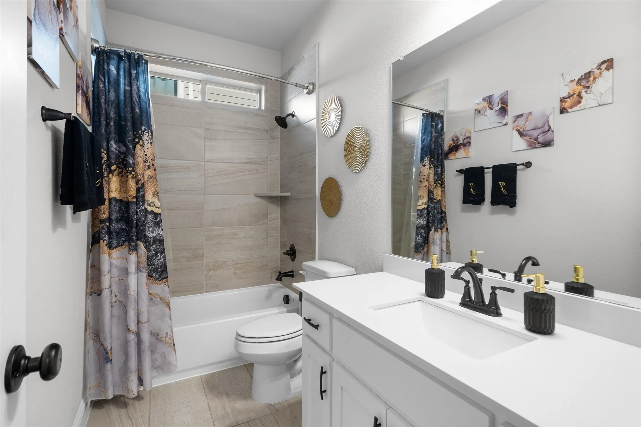 Bathroom featuring a white vanity with integrated sink, a rectangular mirror, a bathtub with tiled surround, and wood-finish flooring