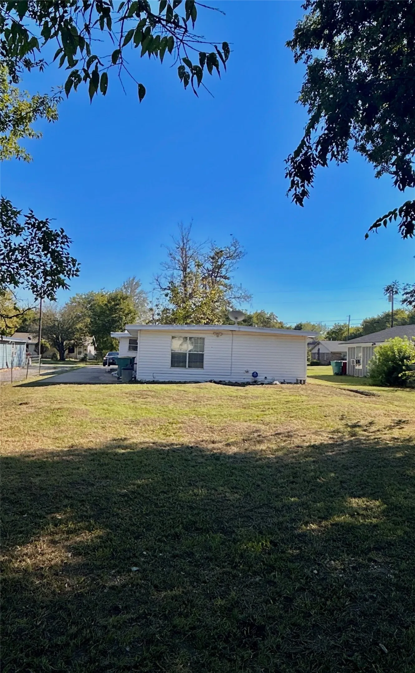 Expansive grassy yard with mature trees