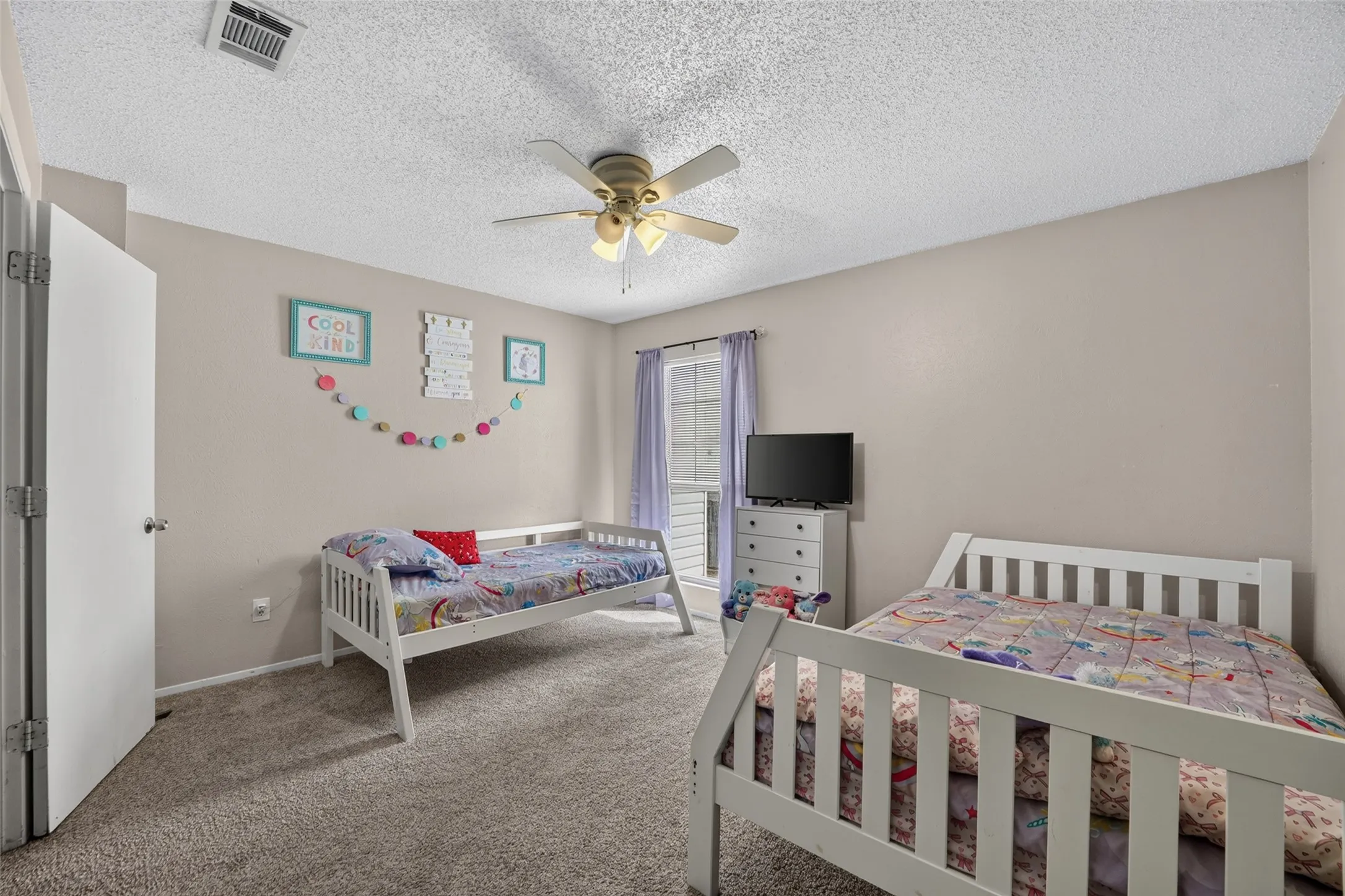 Wall-to-wall carpeting and a ceiling fan with light fixture