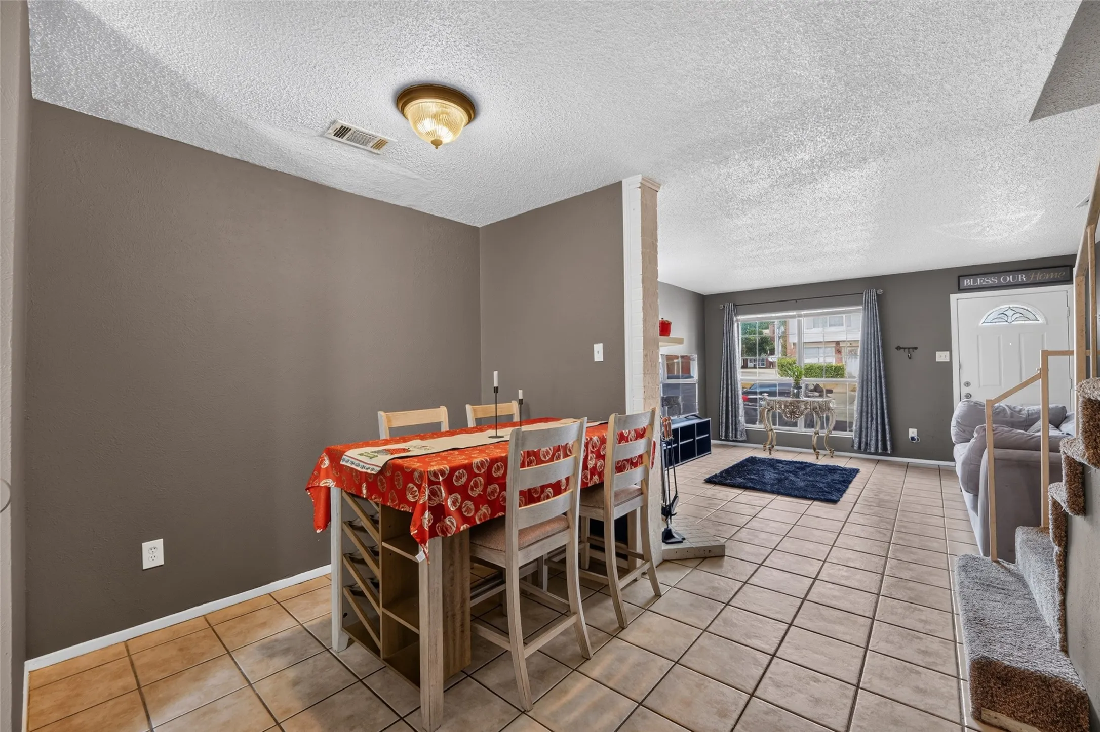Tiled flooring spans the main level with a decorative ceiling light fixture