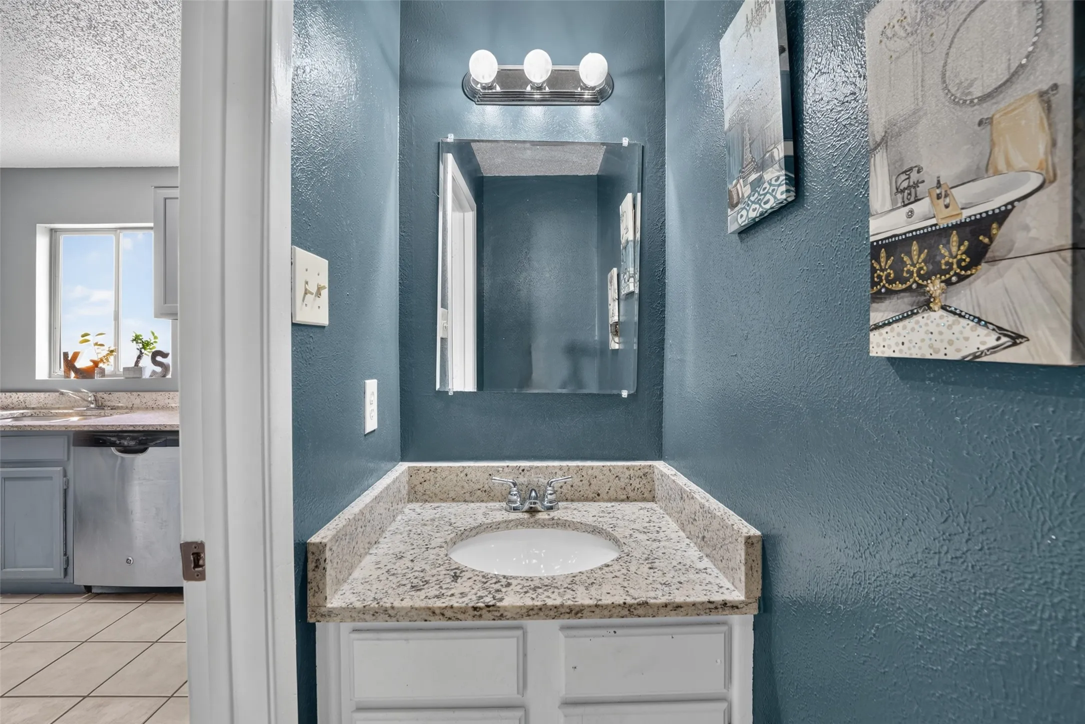 Vanity with integrated sink, granite-pattern countertop, and chrome fixture