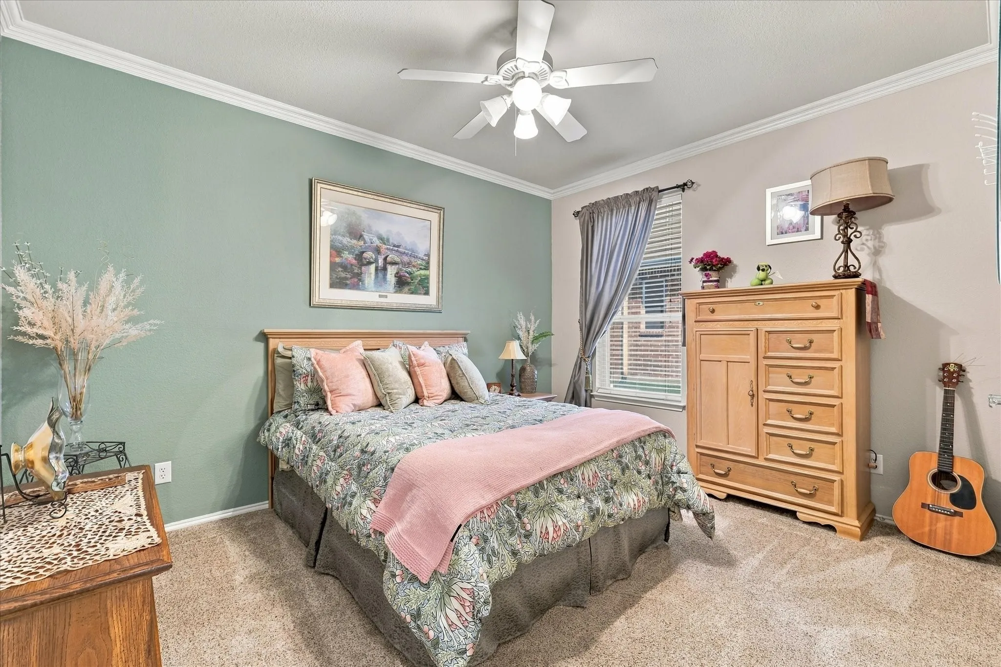 Crown molding, textured carpeting, ceiling fan, and a window with blinds