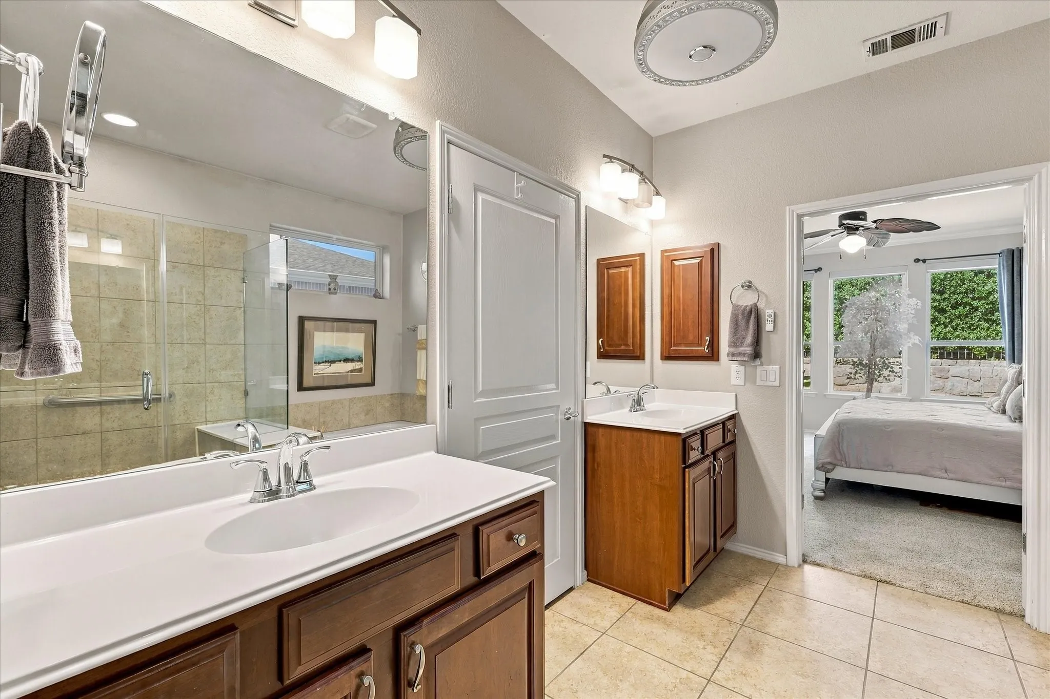 Primary Bathroom with double vanity with wood-finish cabinetry