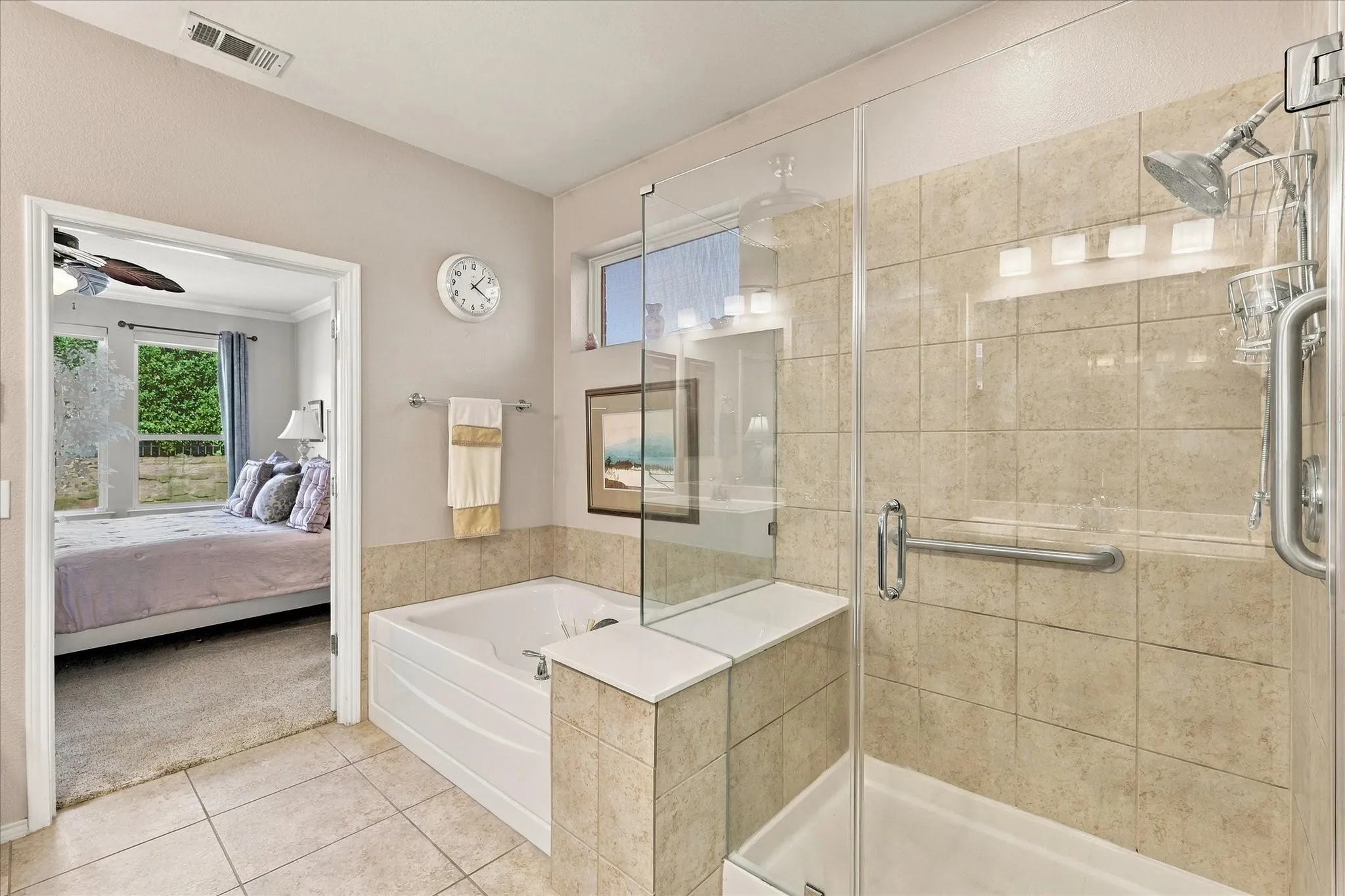 Primary Bathroom with Walk-in shower with clear glass enclosure and tile surround, accompanied by a built-in glamour tub