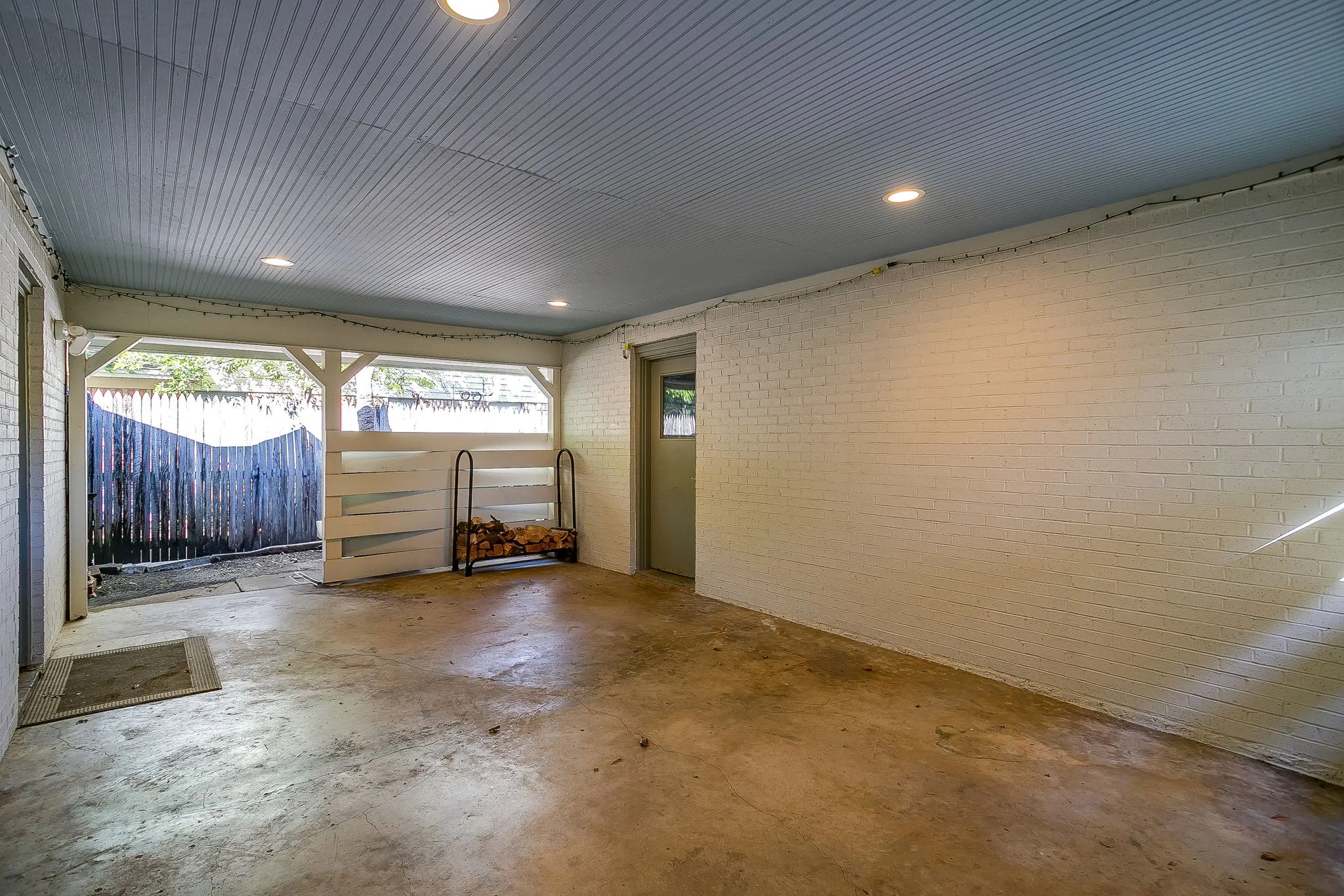 Painted brick walls, corrugated ceiling, recessed lighting, and a concrete floor