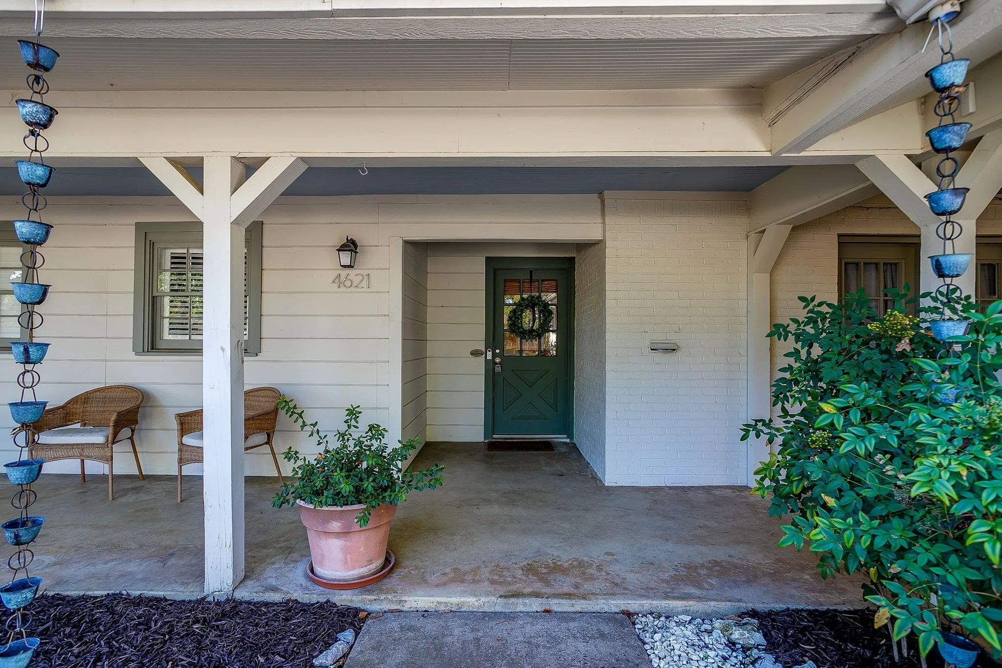 Covered porch with concrete flooring and exposed beam detailing