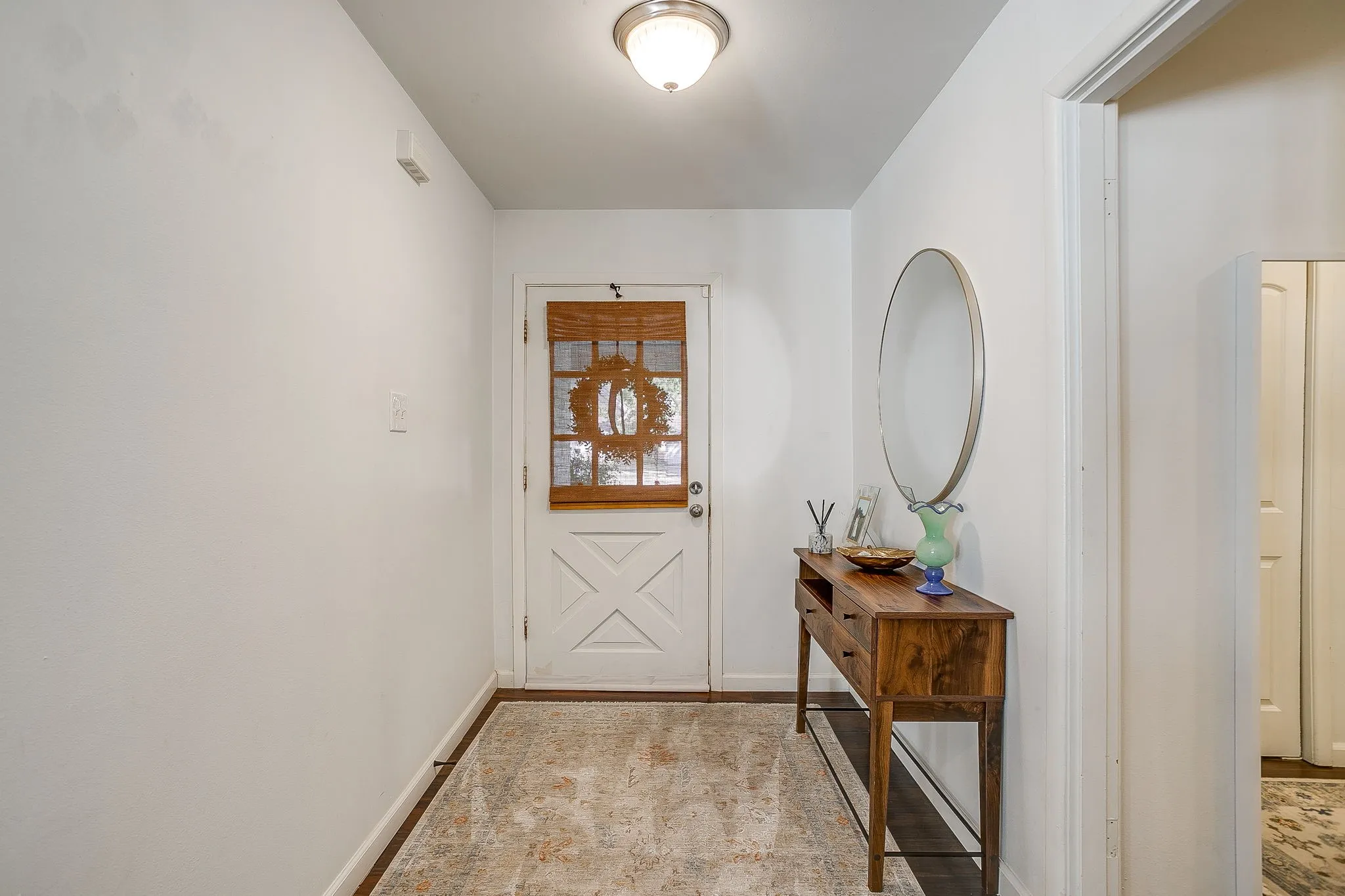 White interior walls with a flush-mount ceiling light
