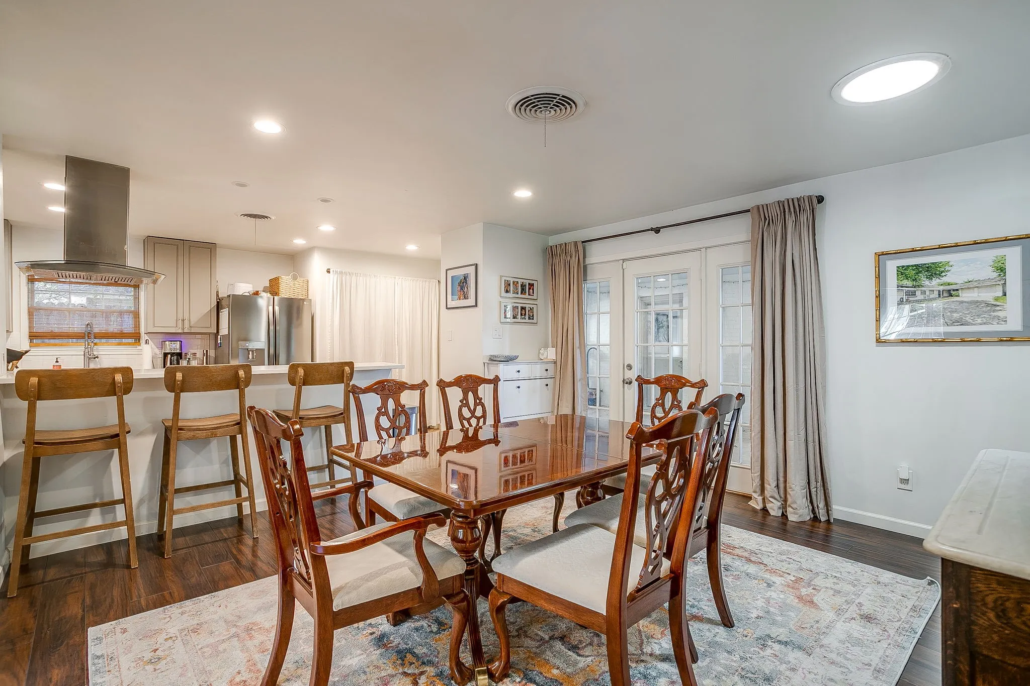Dark wood-finish flooring, white walls, and a recessed skylight