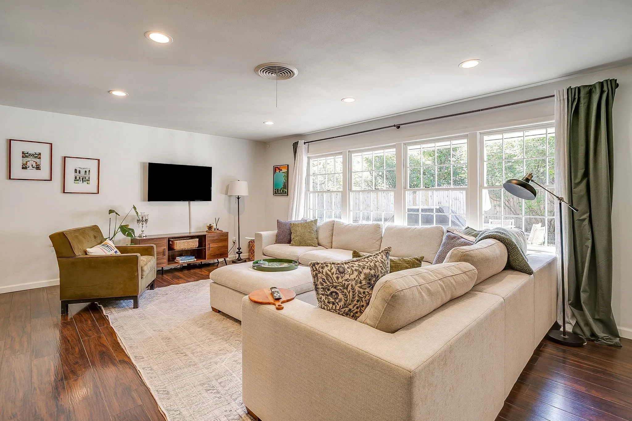 Recessed ceiling lighting, dark wood-finish flooring, white walls, and a multi-pane window with white trim