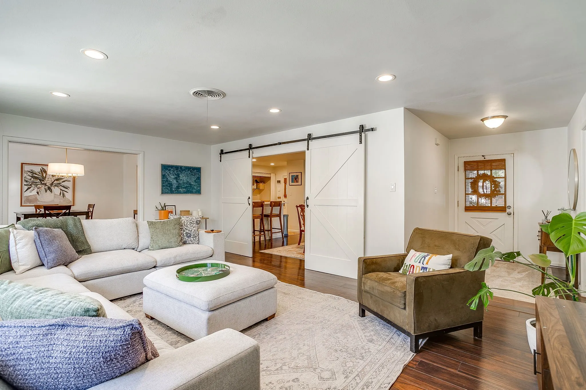 Hardwood-style flooring throughout, recessed lighting, and white barn-style sliding doors