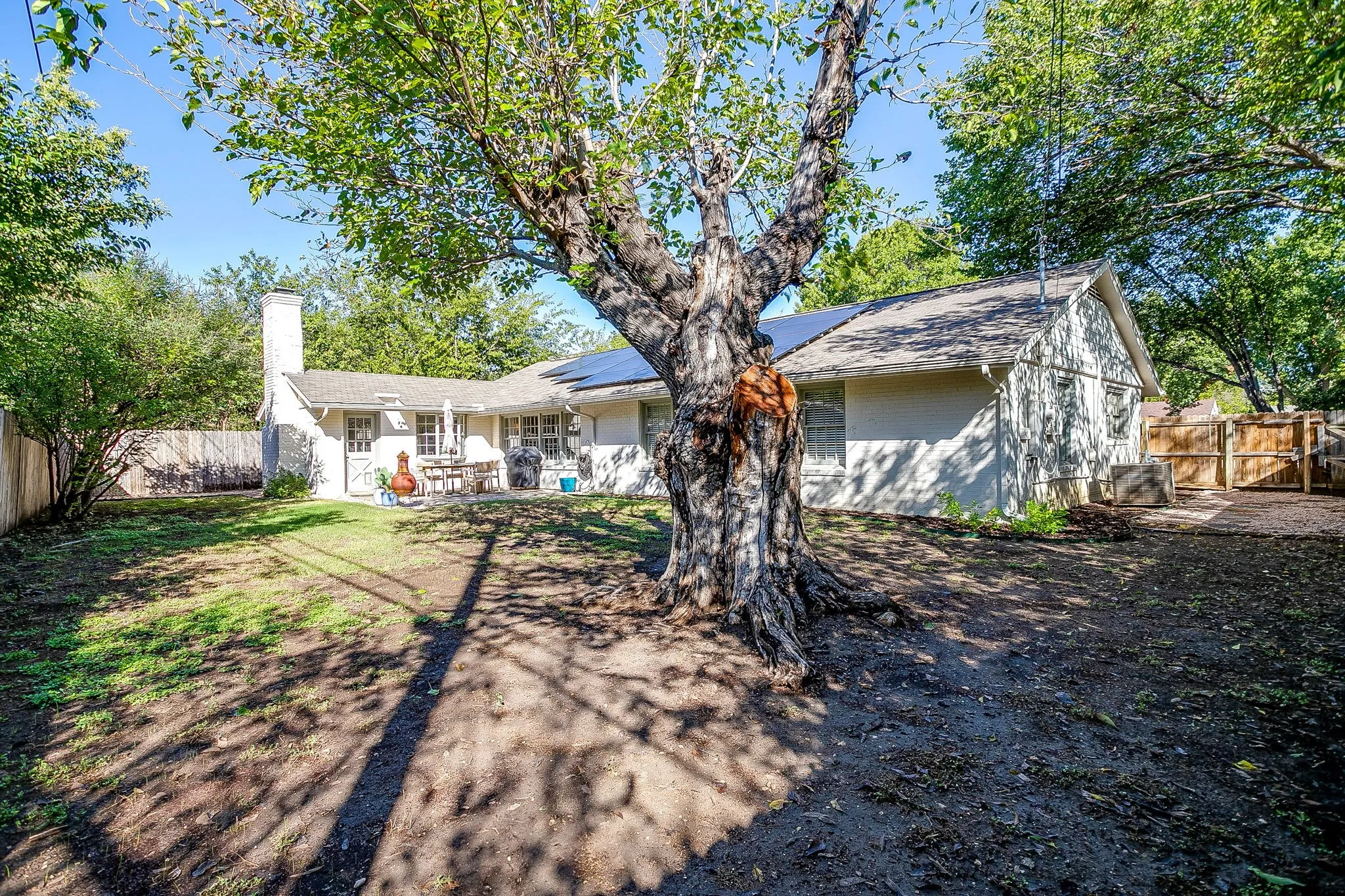 Expansive rear yard featuring mature trees and a fenced perimeter