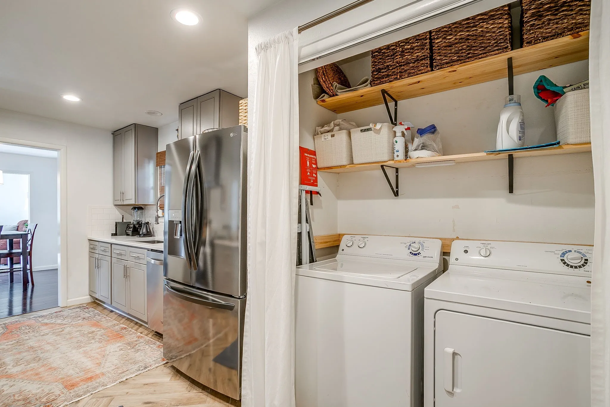 Kitchen featuring stainless steel refrigerator, white subway tile backsplash, and light-toned cabinetry