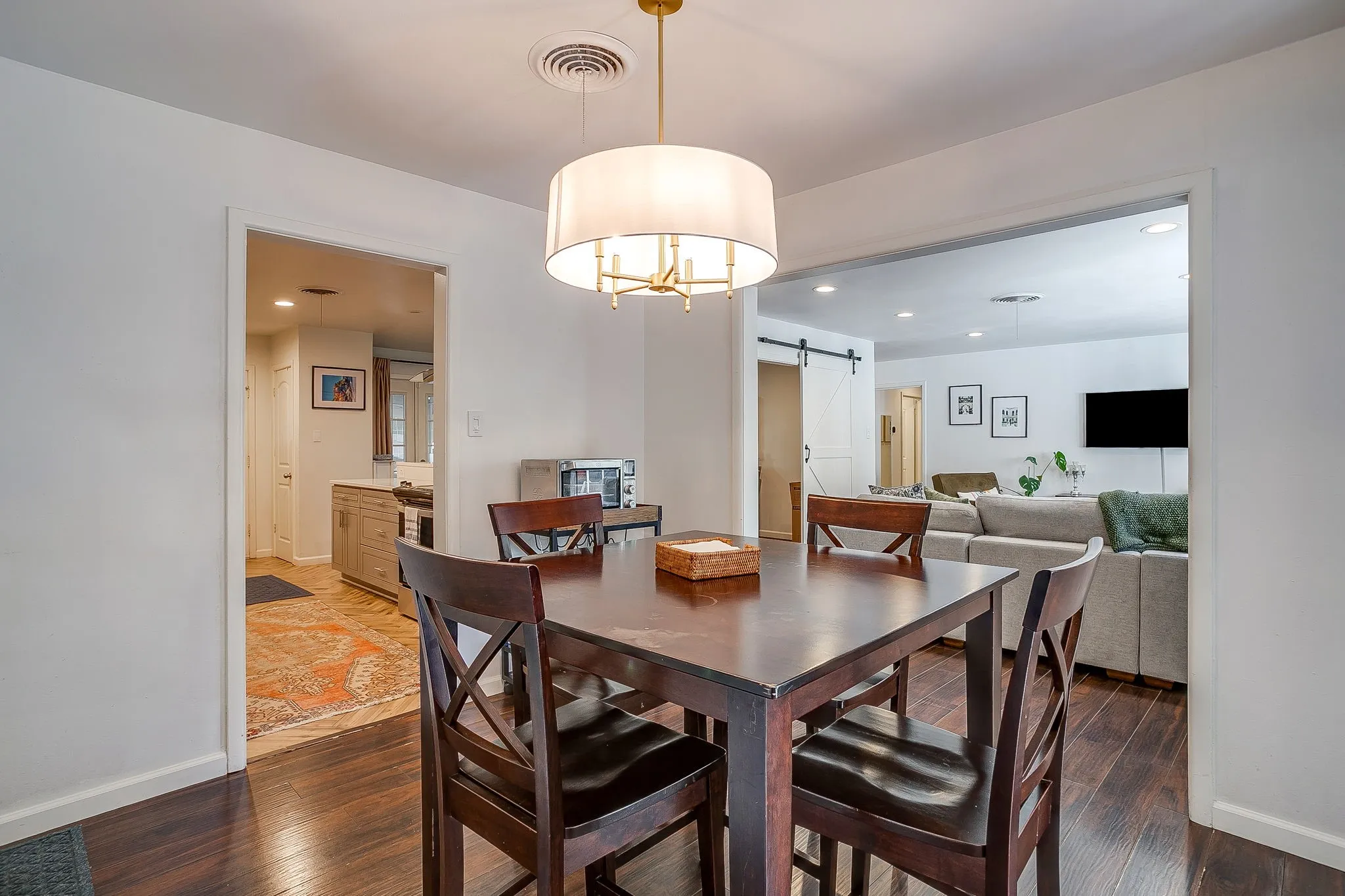 Hardwood-finish flooring throughout, modern drum pendant light fixture, crisp white walls, and recessed lighting