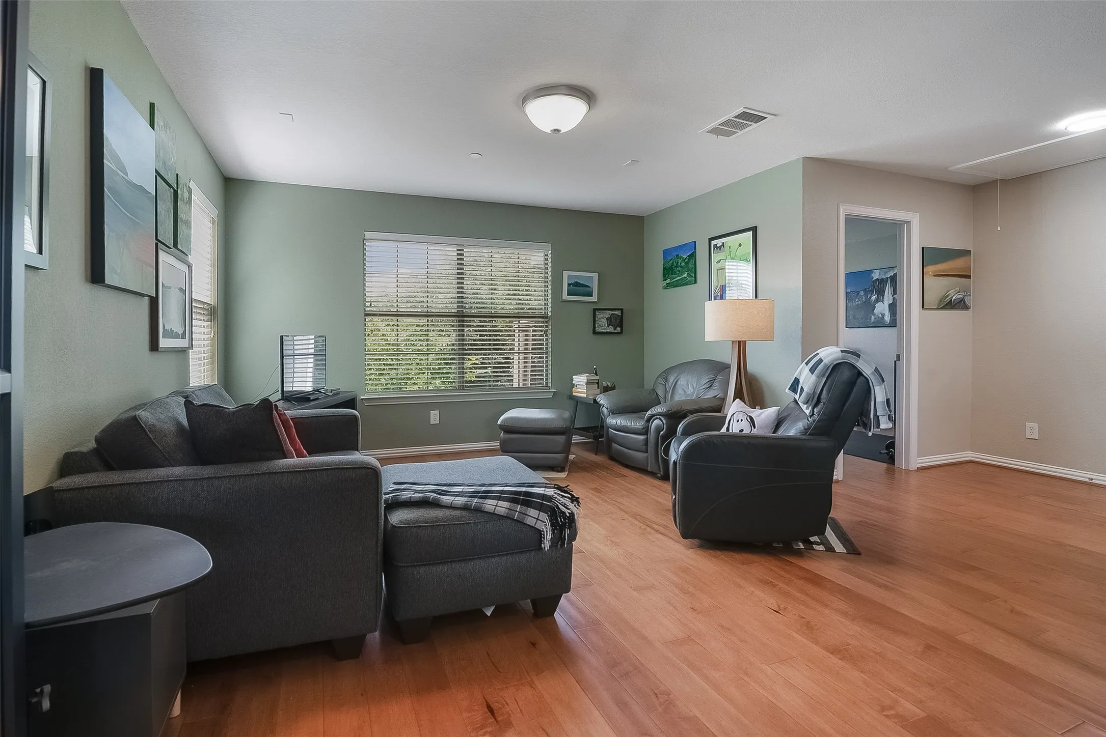 Wood-finish flooring throughout, complemented by a window with blinds providing natural light