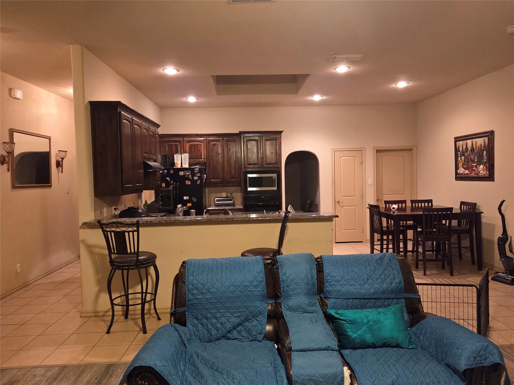 Kitchen featuring dark wood cabinetry, granite-style countertops, and stainless steel appliances