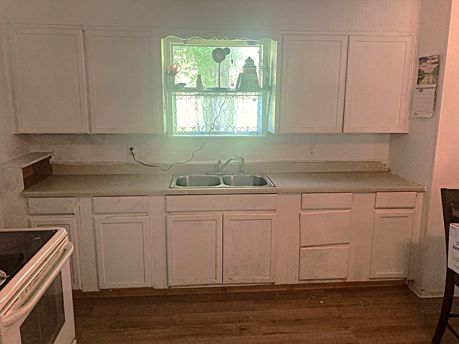 Kitchen with white cabinetry, a double basin stainless steel sink, and light-toned countertops