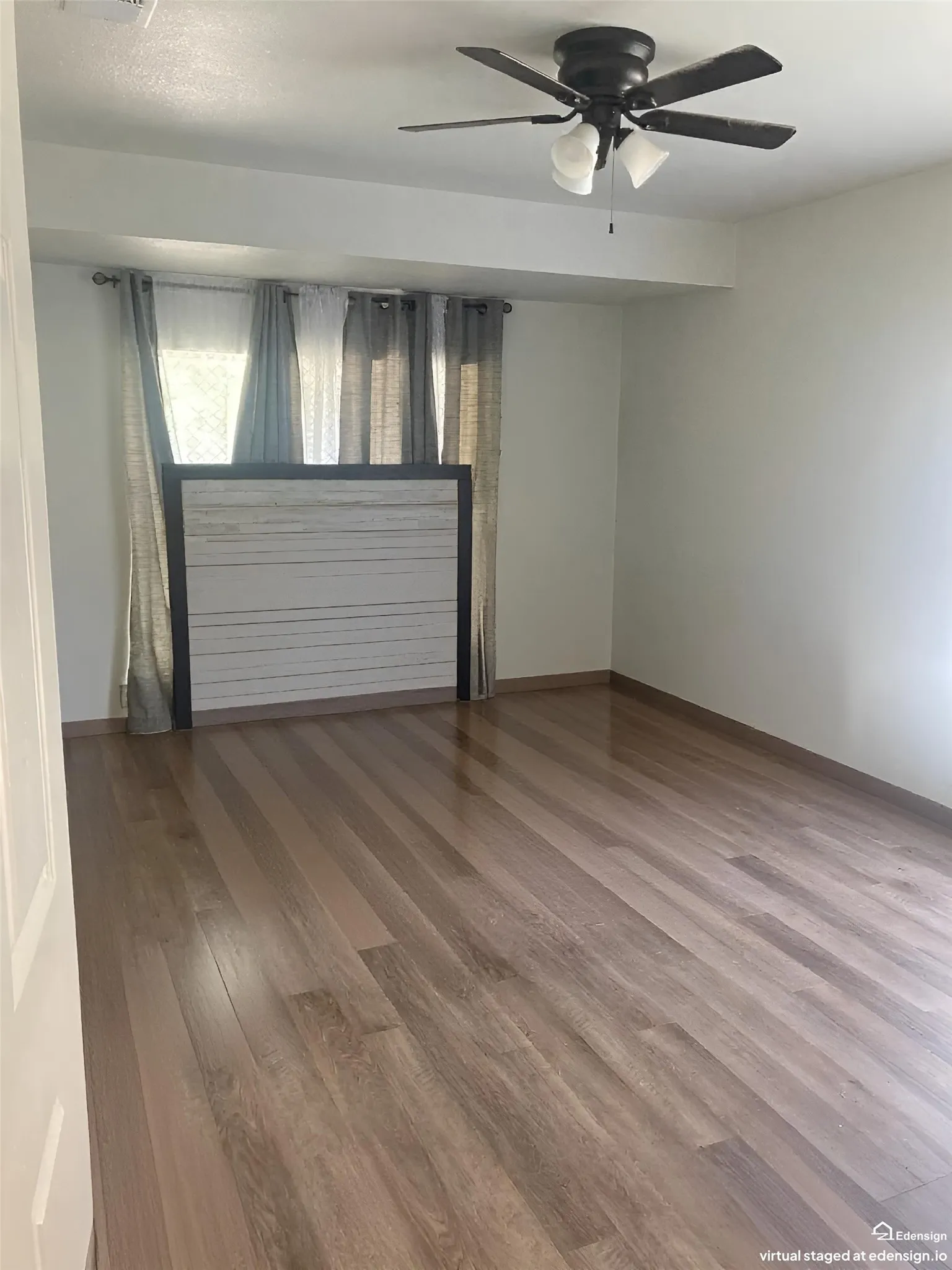 Wood-finish flooring throughout, ceiling fan with integrated lighting, and neutral wall tones