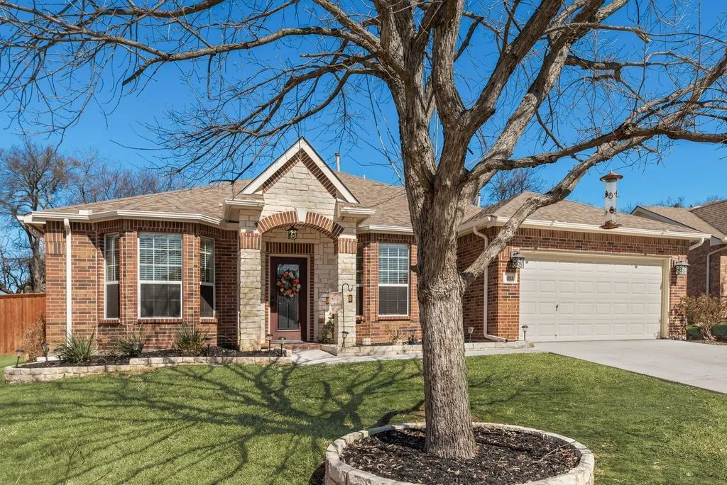 Brick exterior with stone accents, covered entry, bay windows, and an attached two-car garage
