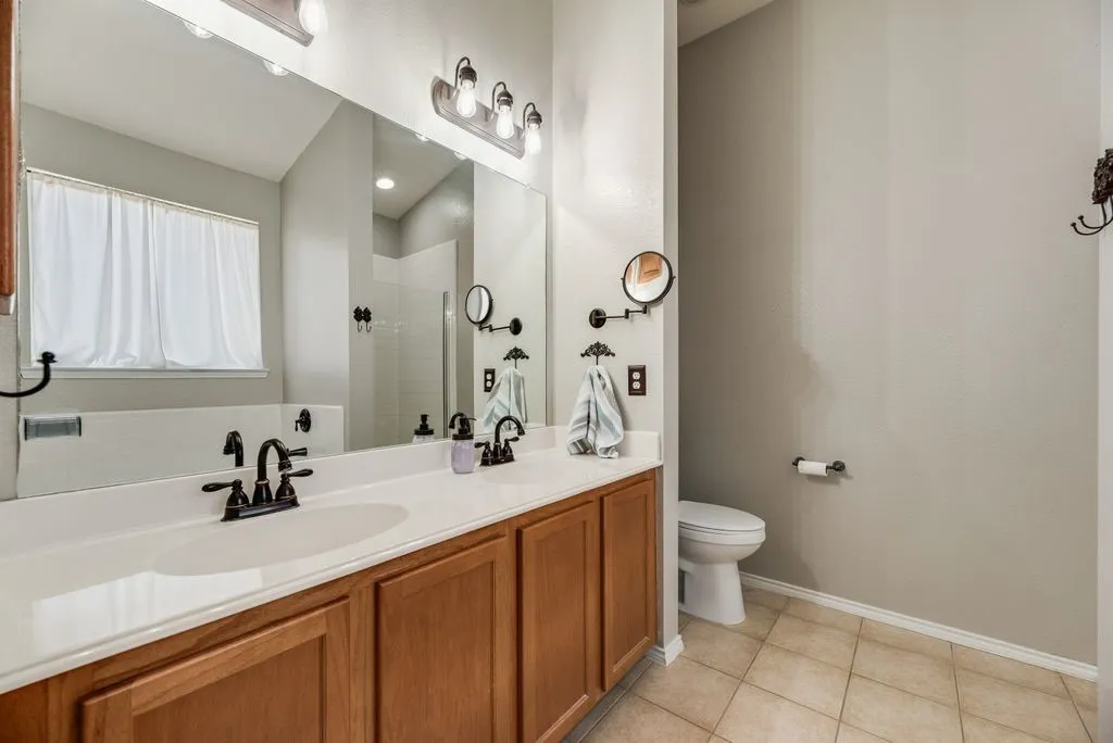 Dual vanity with integrated sinks, wood cabinetry, and oil-rubbed bronze fixtures