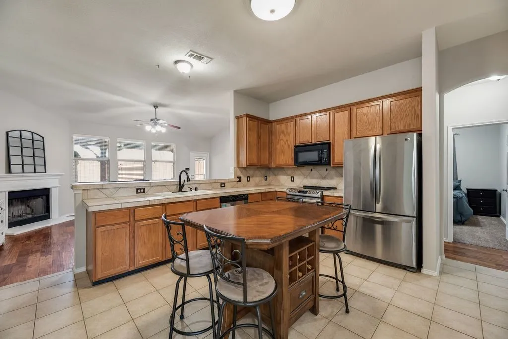Kitchen featuring wood cabinetry, stainless steel appliances, and a tiled backsplash