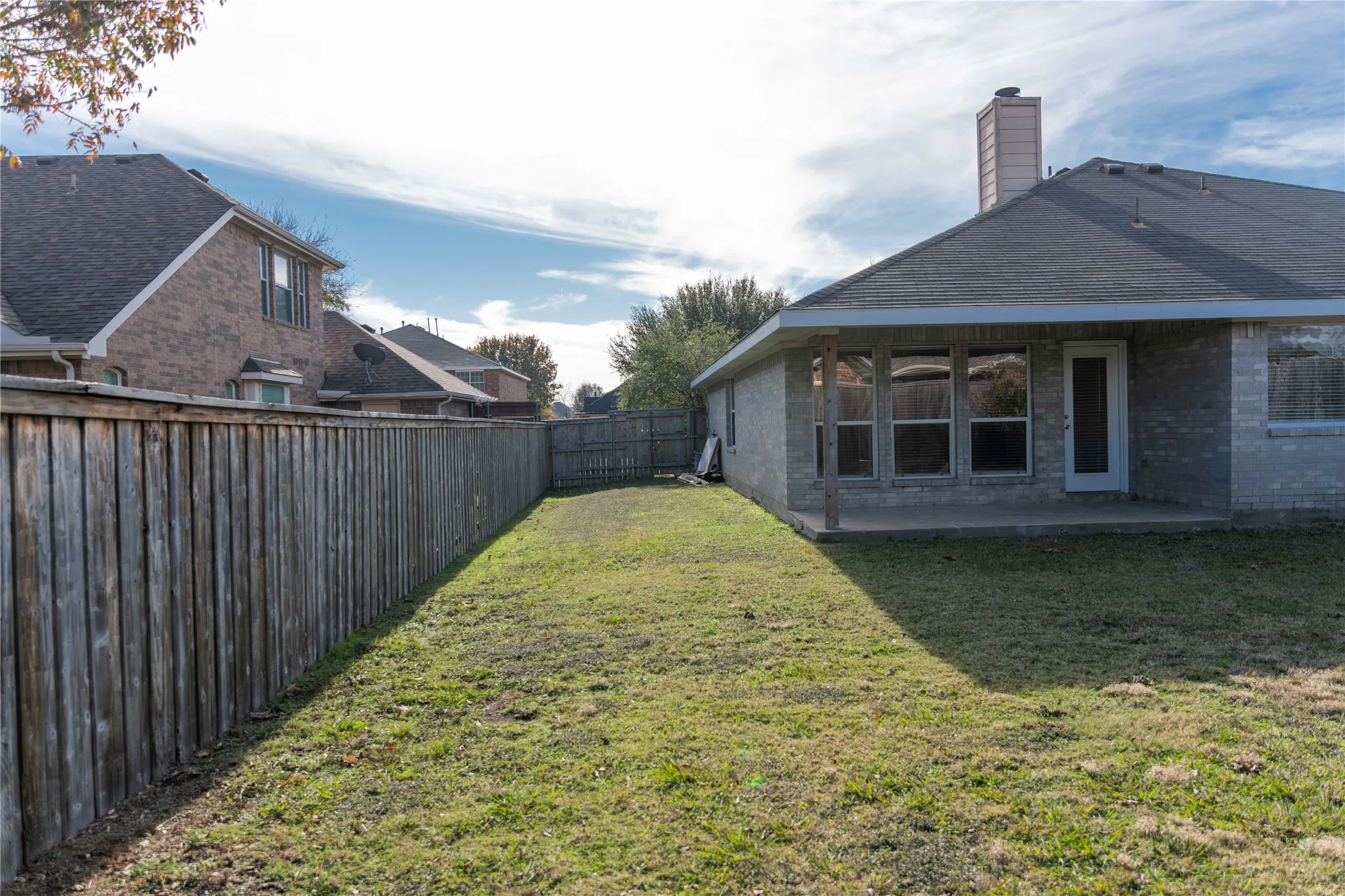 Fenced backyard with a covered patio, brick exterior, and a shingle​​‌​​​​‌​​‌‌​‌‌​​​‌‌​‌​‌​‌​​​‌​​ roof