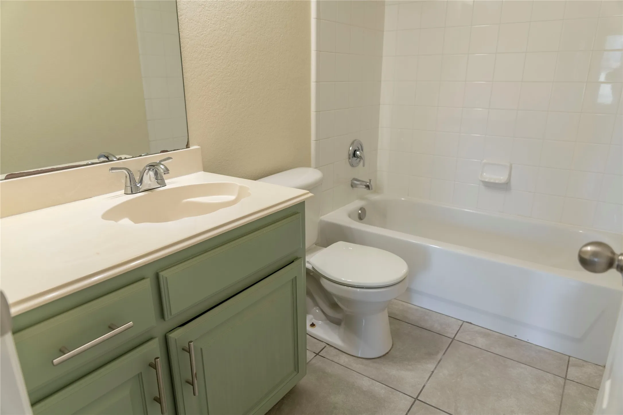 Cream-toned vanity with an integrated sink, chrome faucet, and ample storage