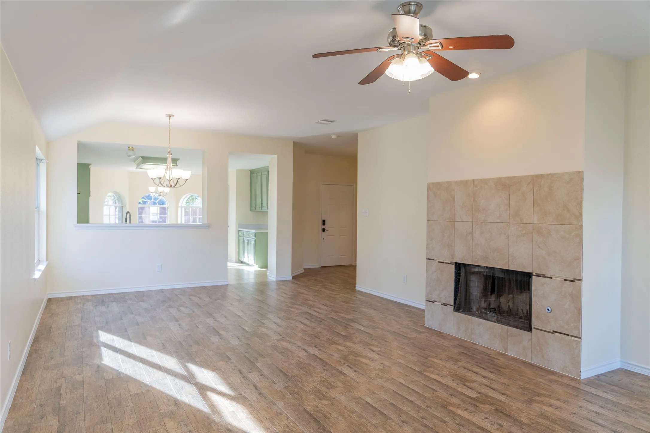 Spacious living area featuring wood-finish flooring and a tiled fireplace