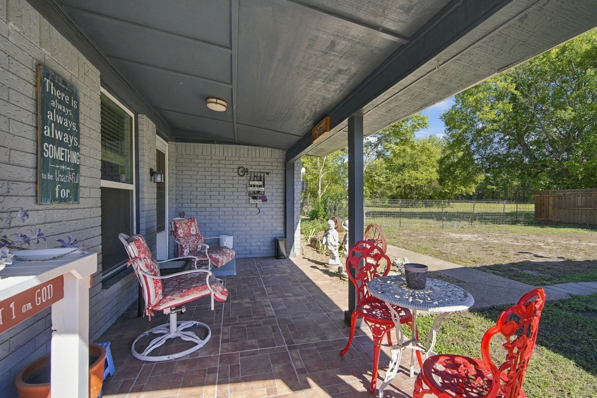 Covered back patio with a tiled floor, painted brick exterior, and recessed lighting