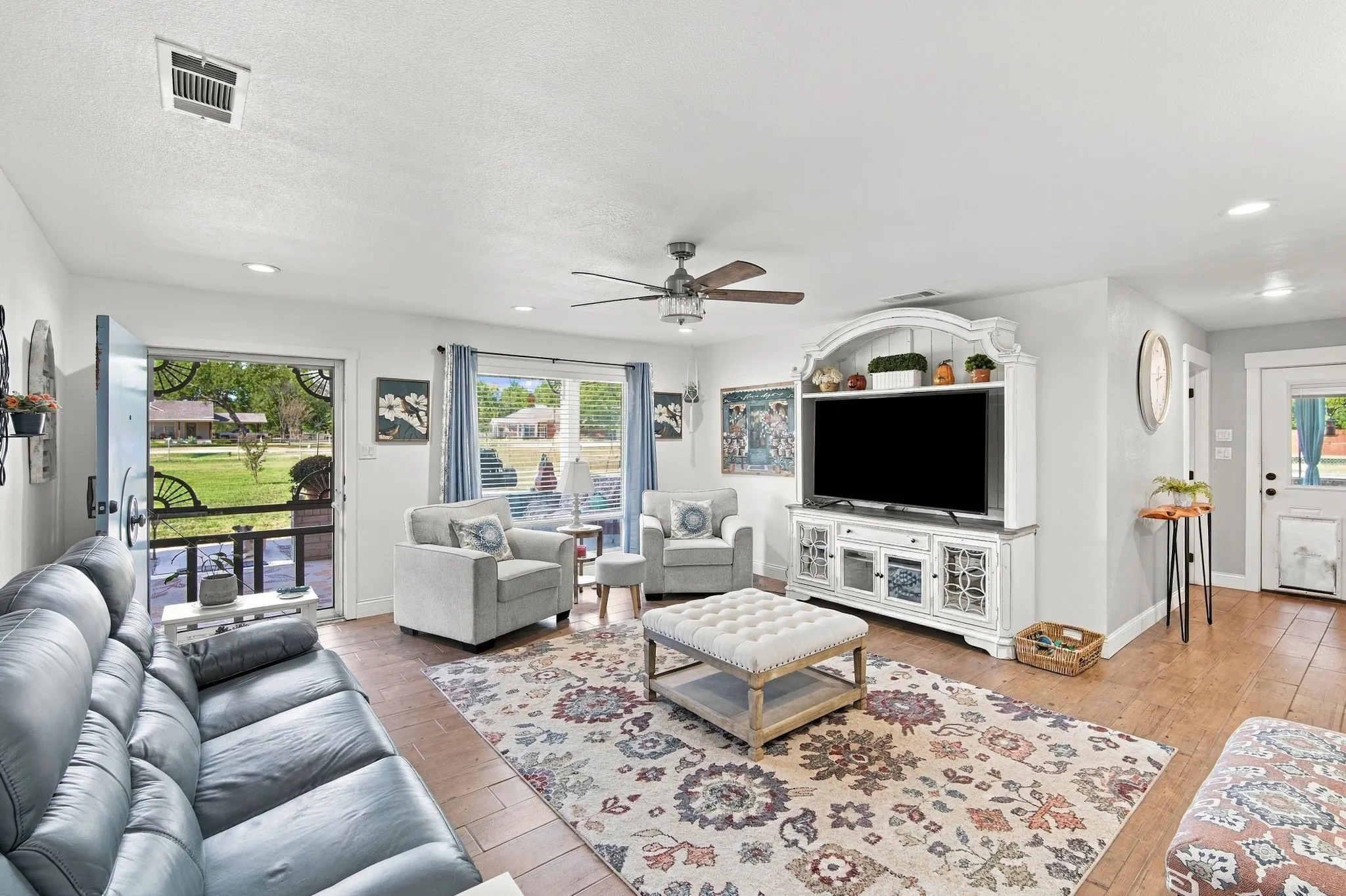 Recessed lighting, wood-finish flooring, ceiling fan, white trim, and a built-in media console