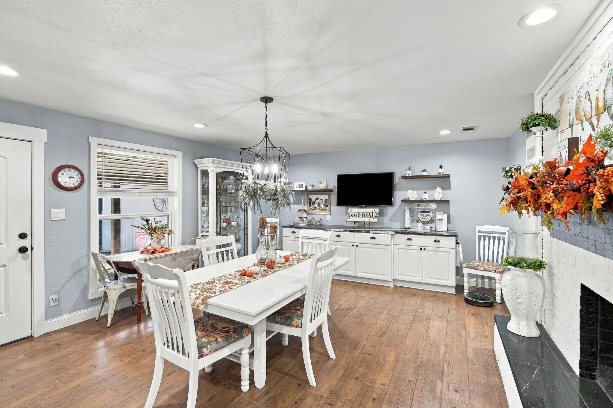 Wood-finish flooring throughout, with a built-in coffee bar built in buffet center featuring lower cabinetry and floating shelves.