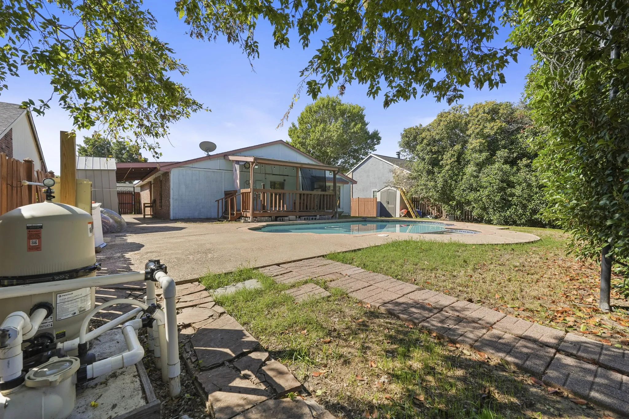 Backyard featuring a built-in swimming pool, paved patio, and a covered porch