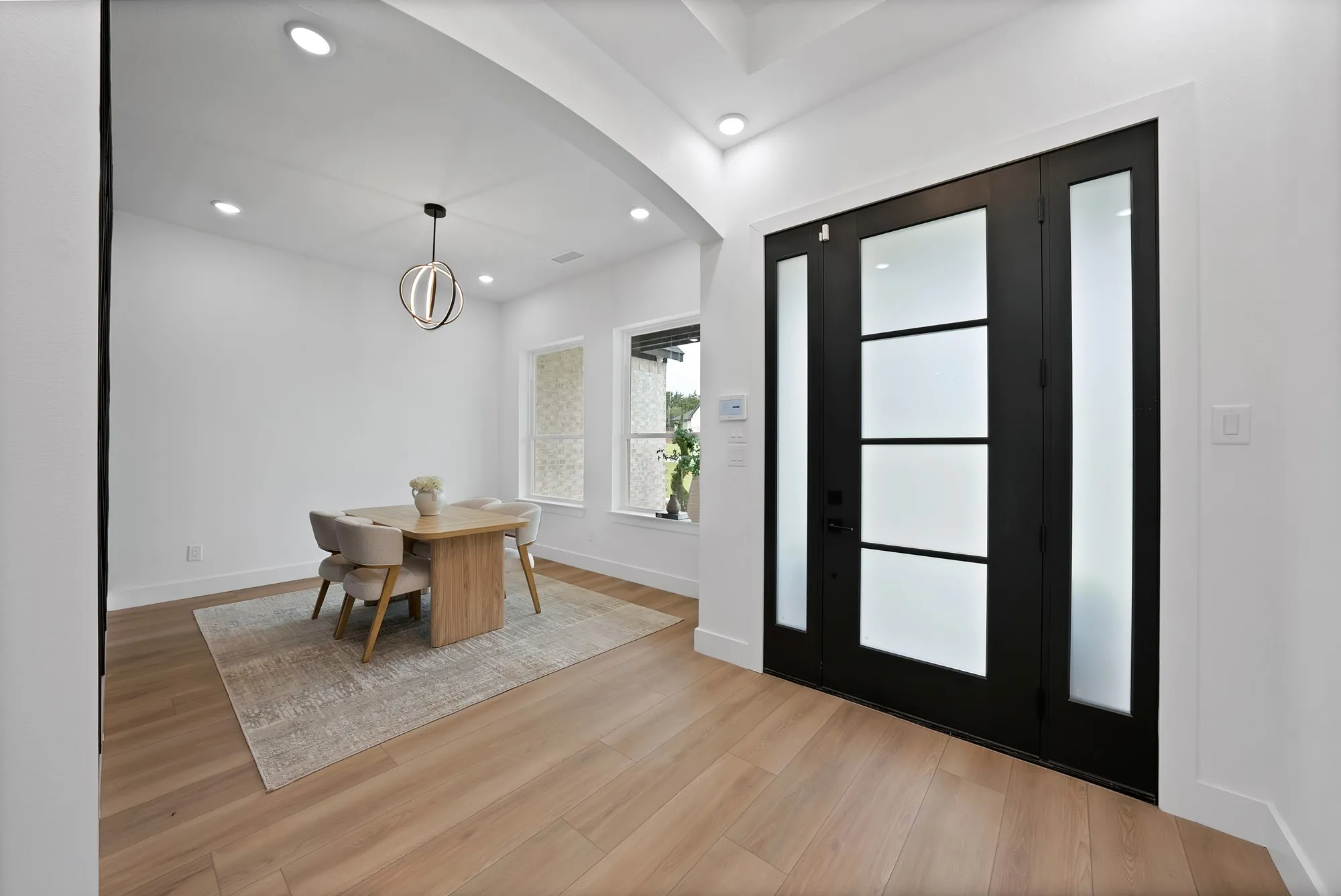 Wide plank wood-finish flooring, recessed lighting, and a modern chandelier