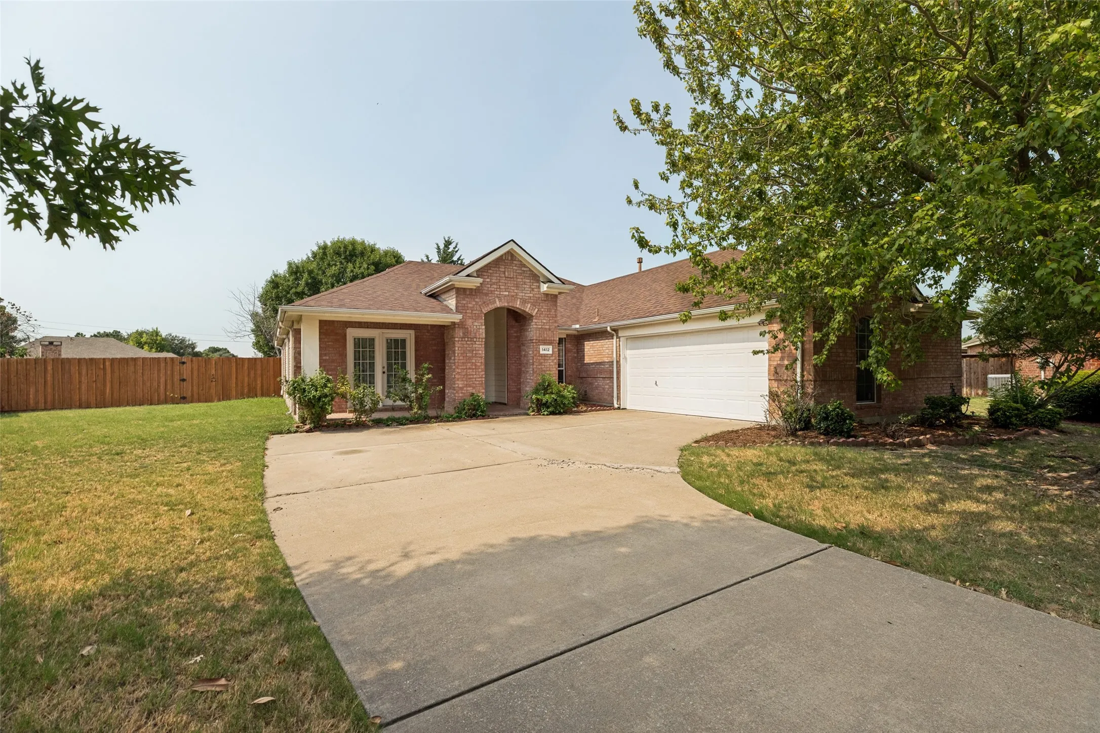 Brick exterior with an arched entryway, double-pane windows, and an attached two-car garage