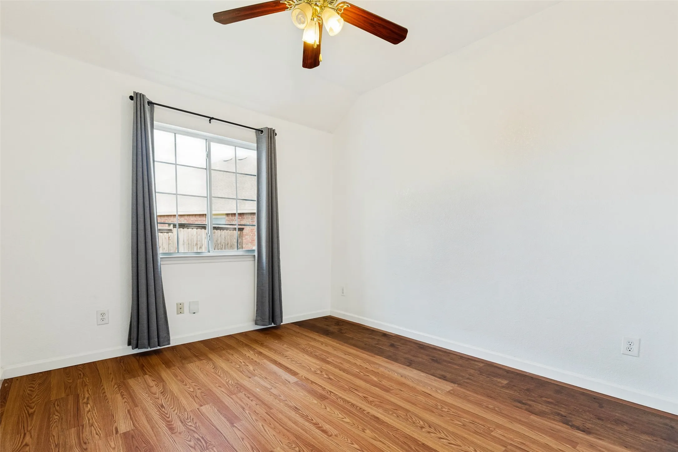 Wood-finish flooring, white walls, and a multi-pane window