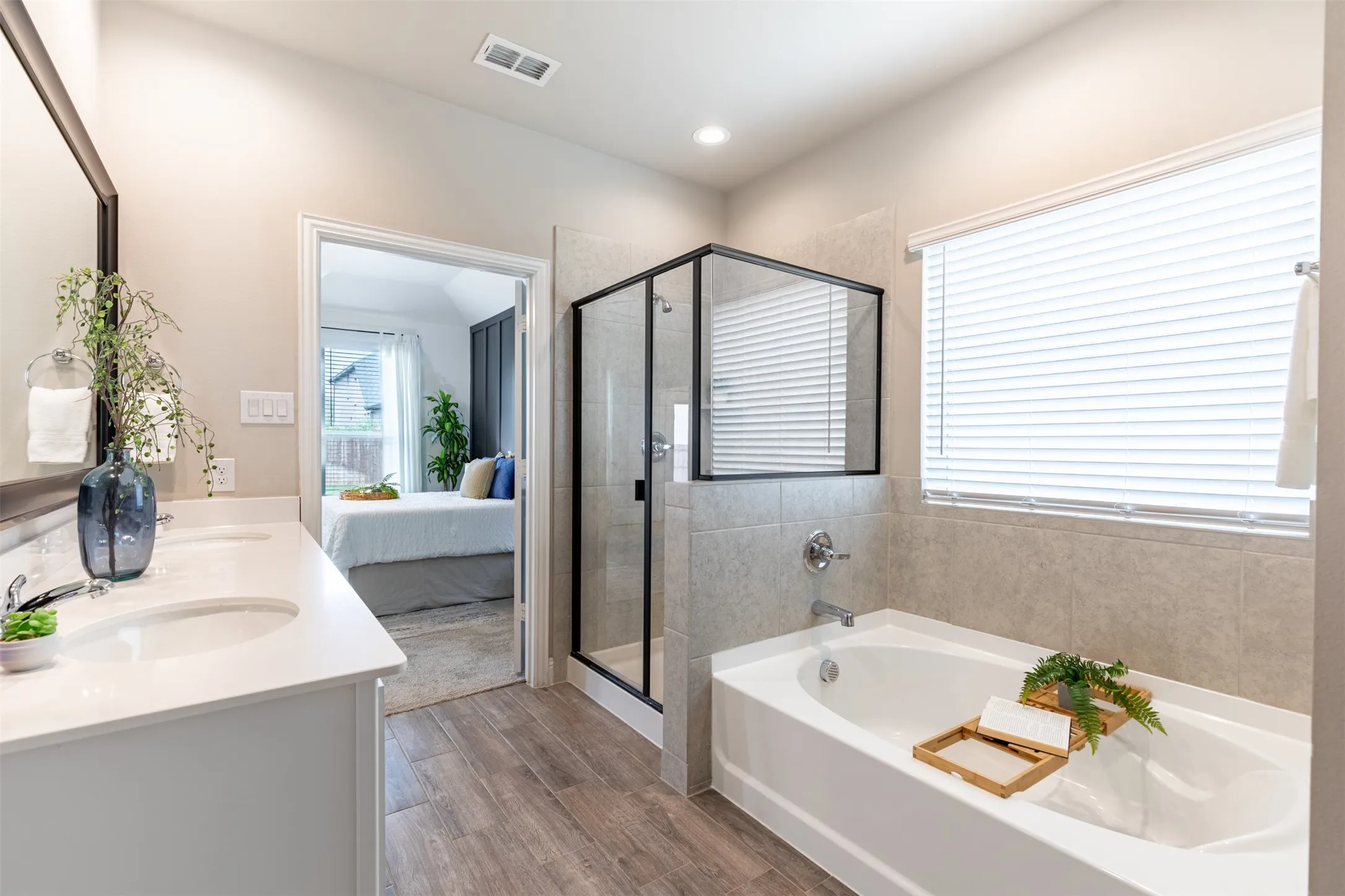 Primary bathroom featuring a relaxing garden tub, separate shower, and large privacy window that fills the space with natural light while maintaining privacy.