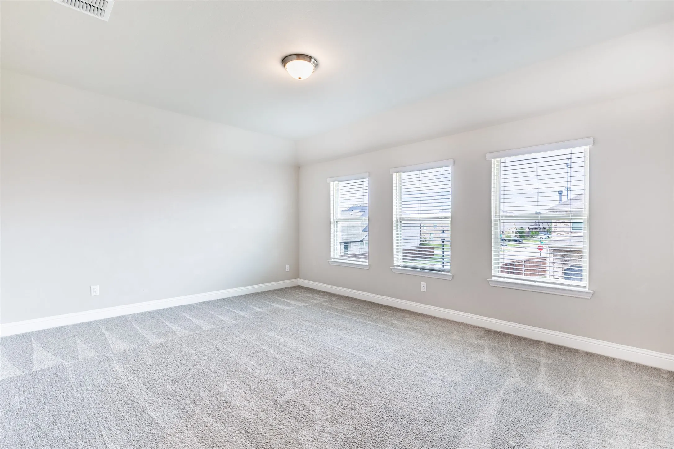Spacious second-floor game room with large windows, abundant natural light, and comfortable carpeting—perfect for entertaining, recreation, or a media space.
