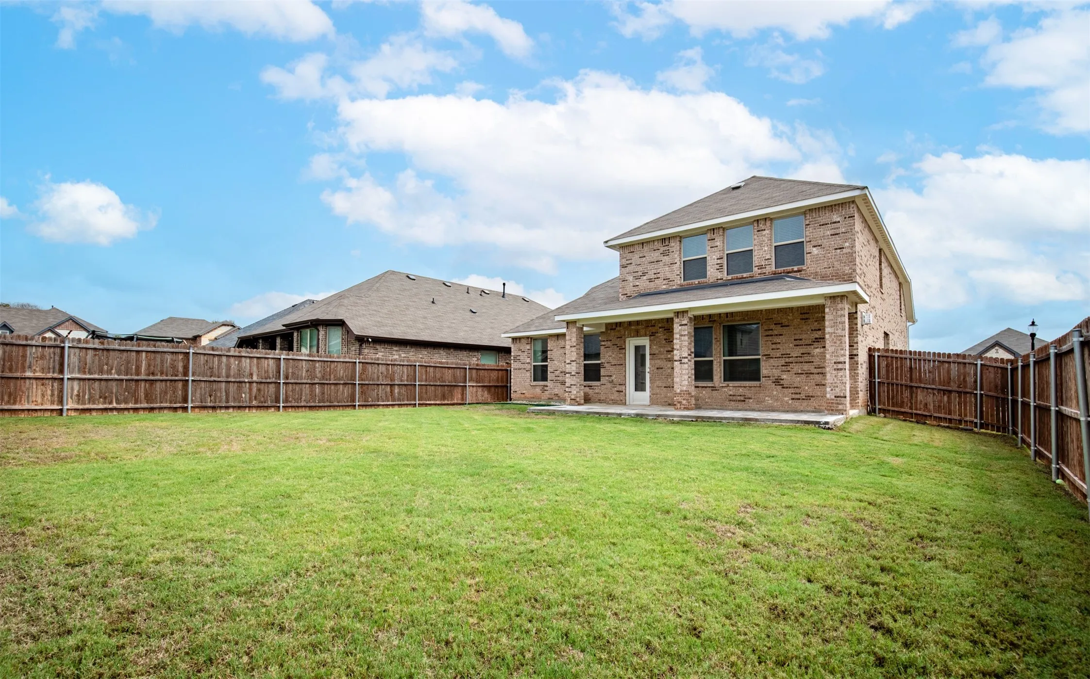 Large backyard with an expansive lawn and ample outdoor space for a playset, pool, outdoor living area, or future backyard upgrades.