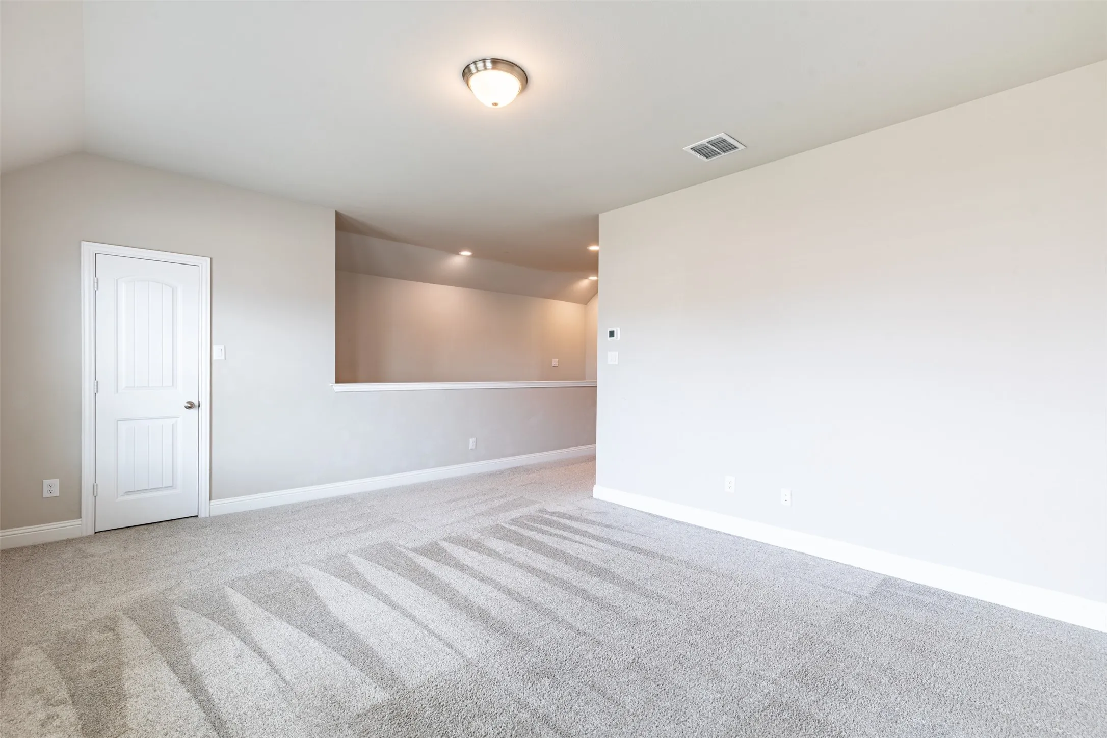 Large second-floor game room with a spacious walk-in closet, providing abundant storage and flexible space for a media room, playroom, home gym, or entertainment area.