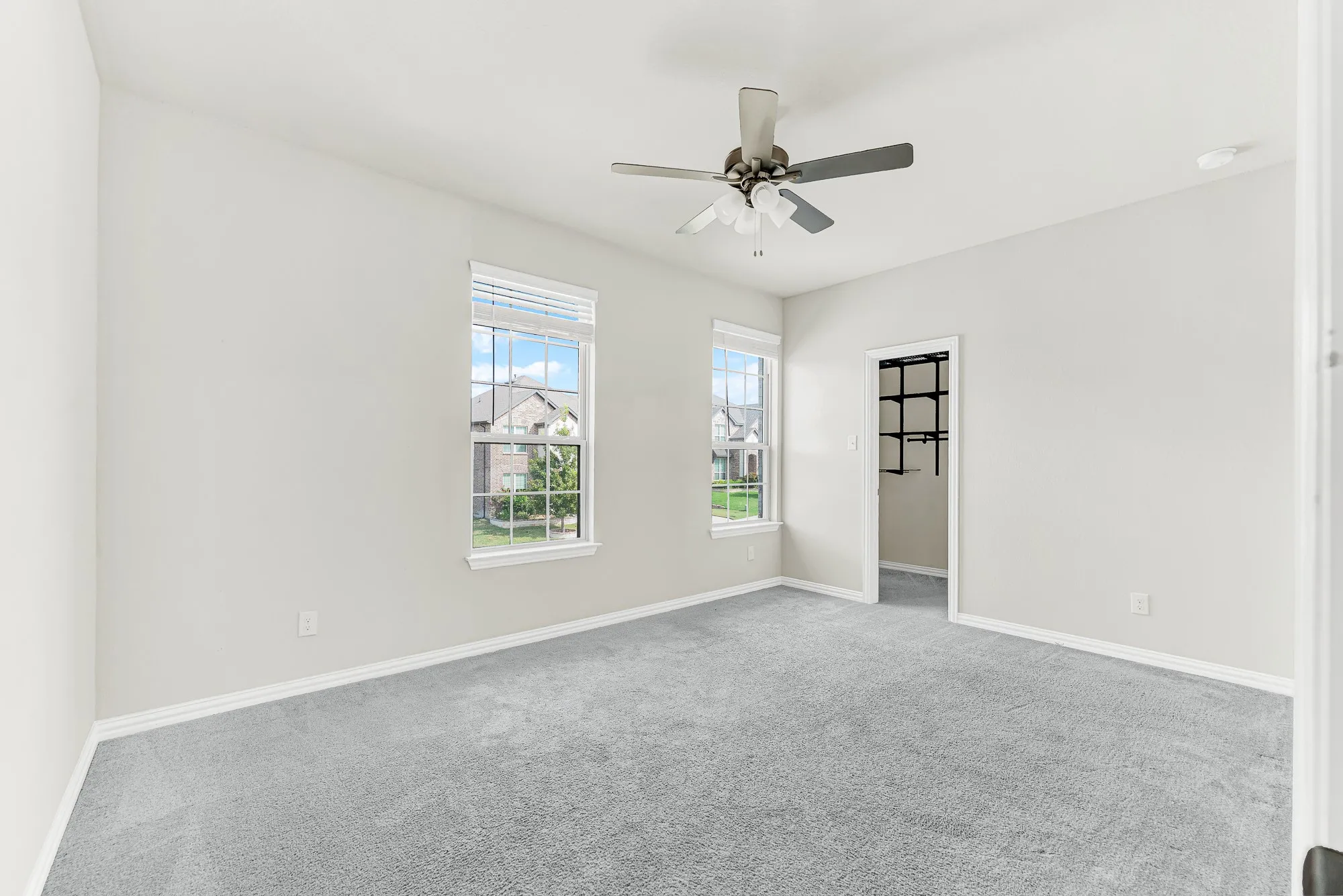 Dual windows look out toward tree views while a walk-in closet offers generous storage options. Picture loved ones unpacking their bags and settling into a bright, welcoming retreat for an extended weekend stay.