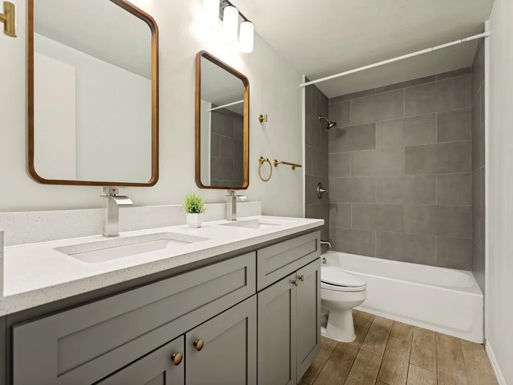 Dual vanity with rectangular undermount sinks, stone-finish countertop, and gray shaker-style cabinetry